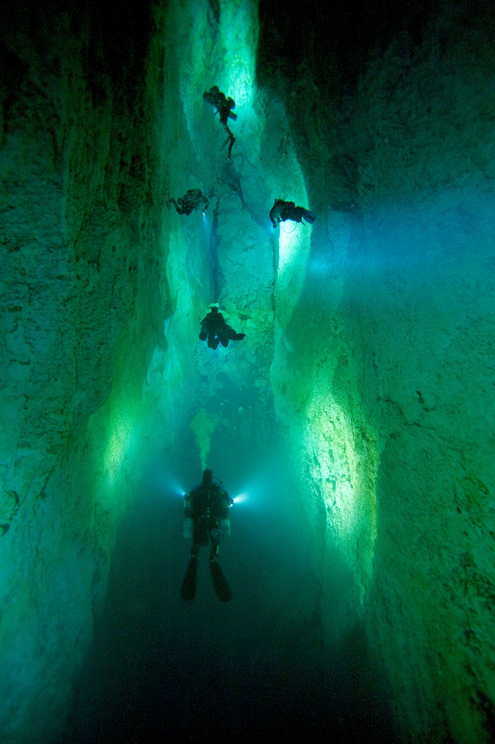 divers illuminating a blue hole on Andros Island