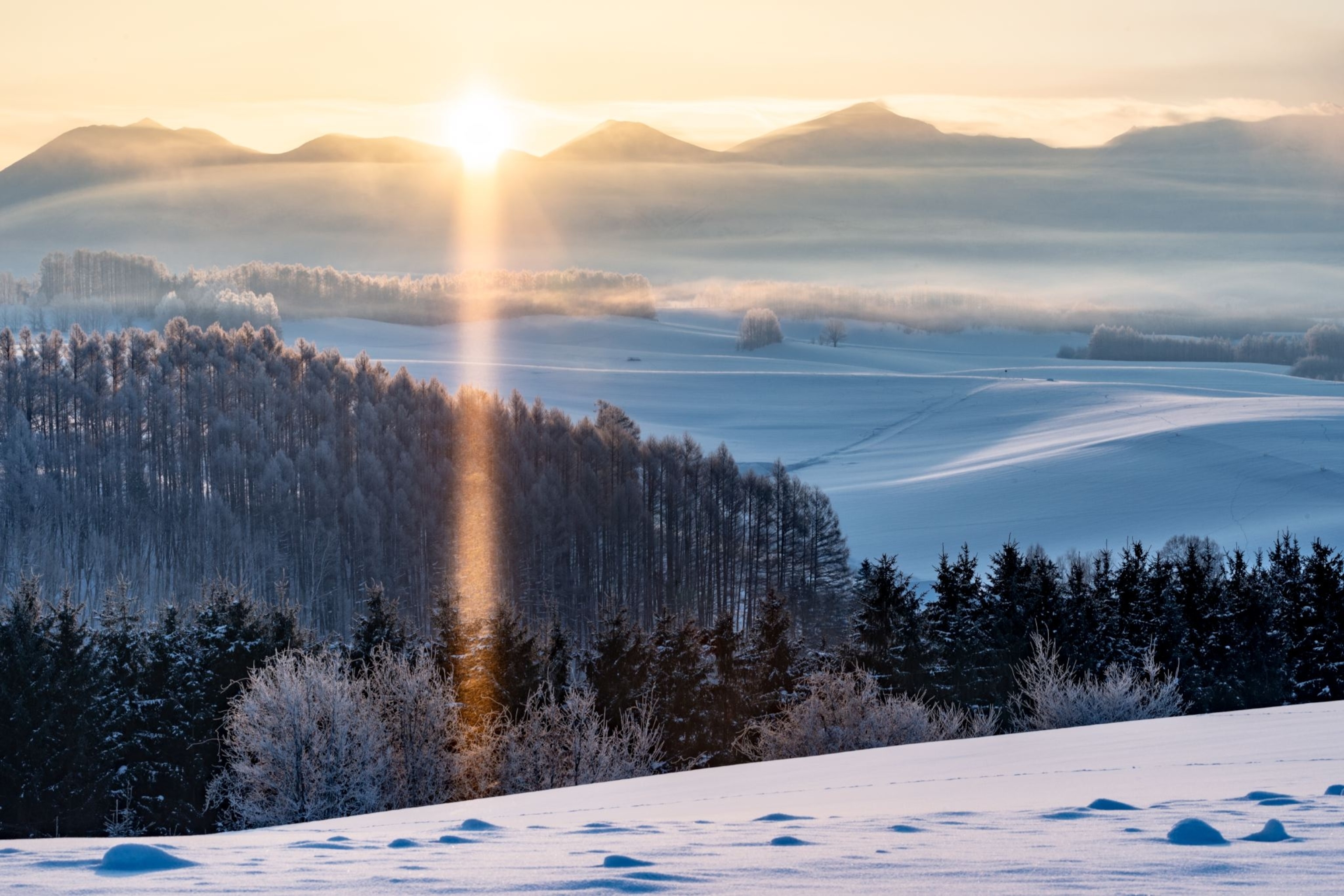 a snowy mountain at sunrise in Hokkaido, Japan
