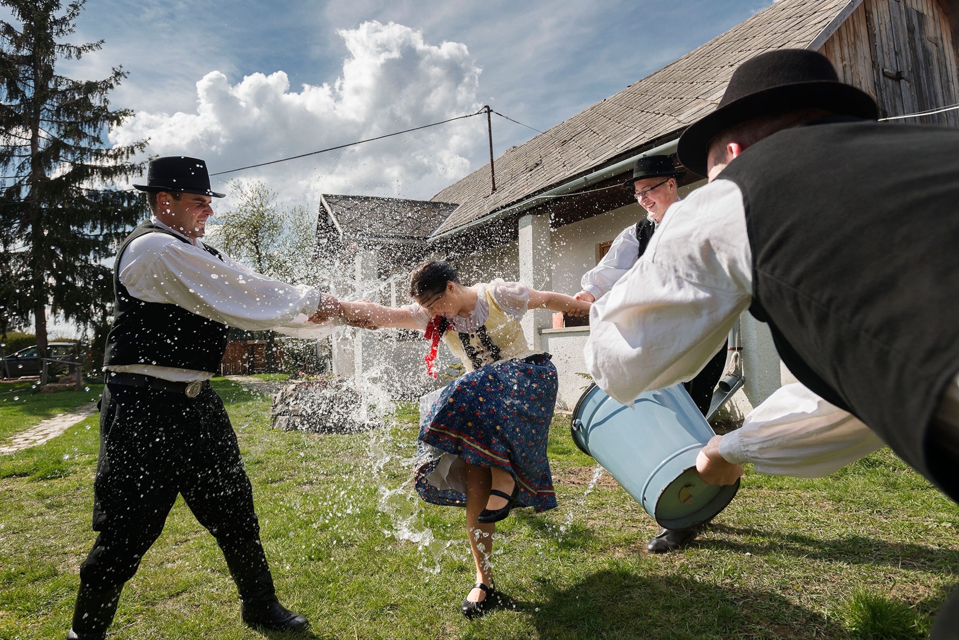 girl in traditional dress getting doused with water