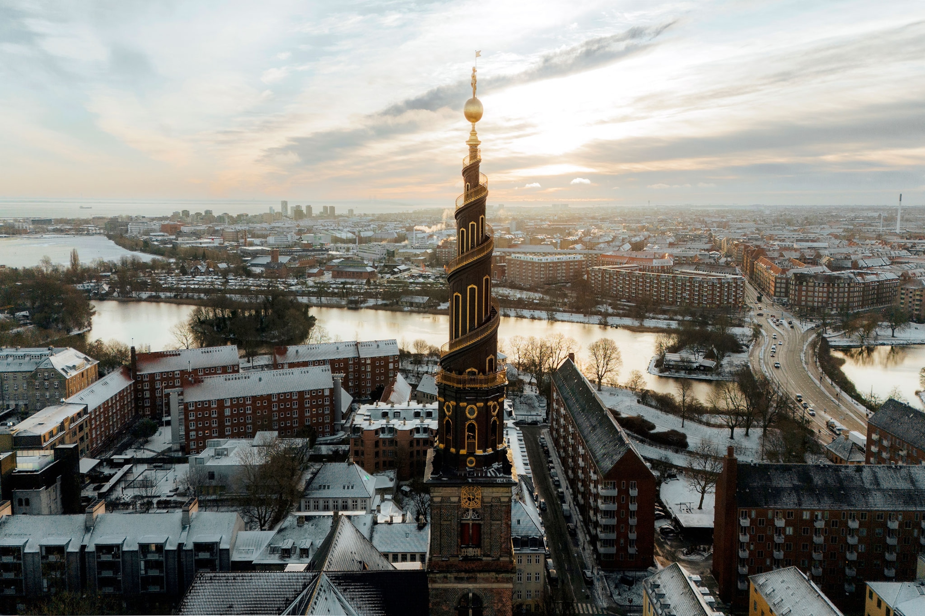 A spiralling church tower is seen above the skyline of Copenhagen.
