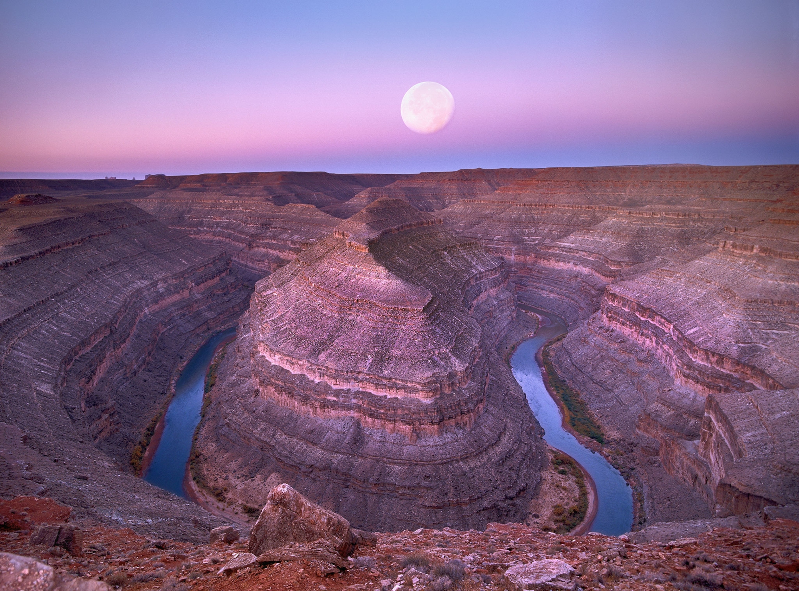 the moon over San Juan River flowing through Goosenecks, Utah.