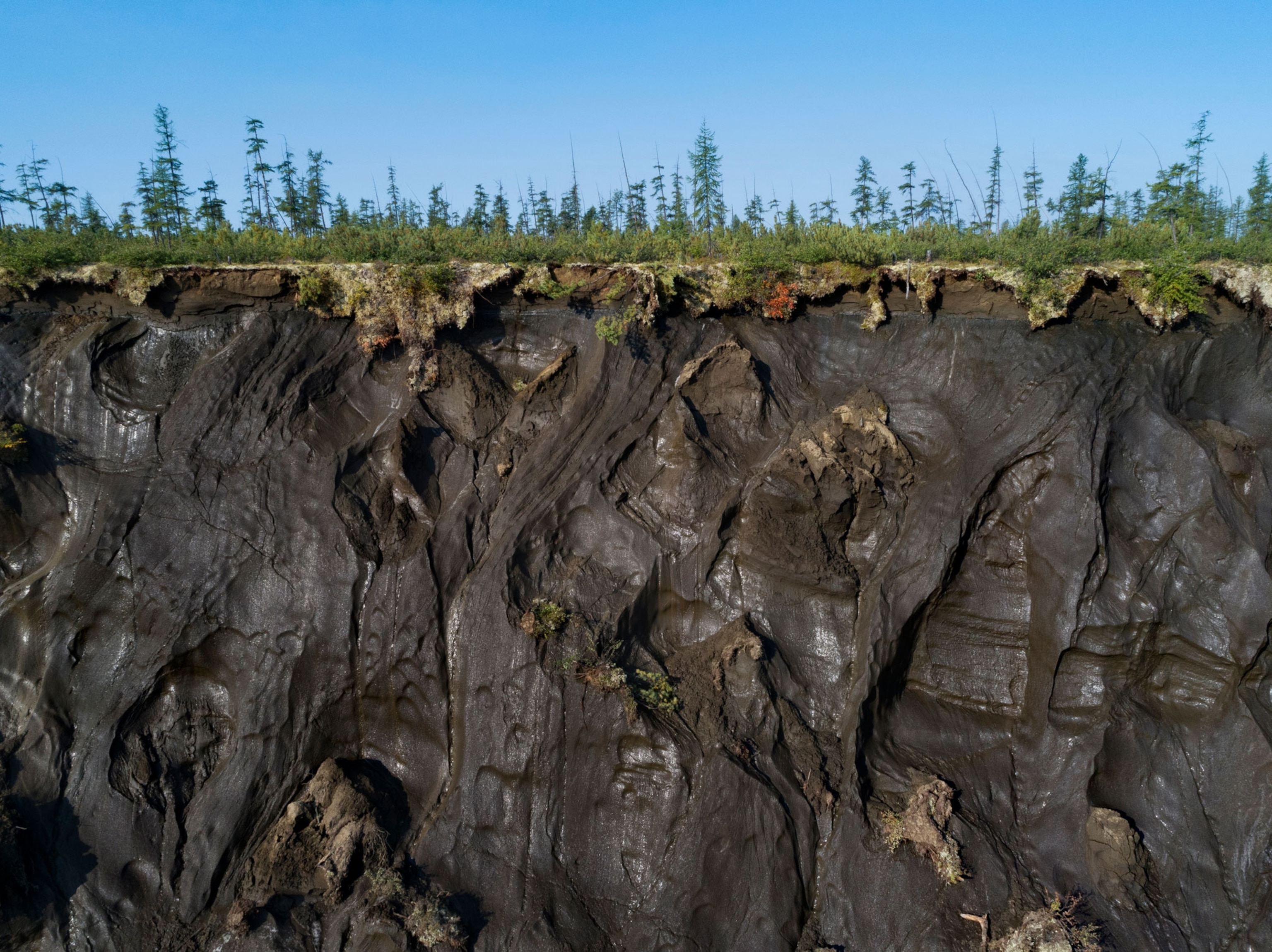 a side video of a steep crater with trees on the surface