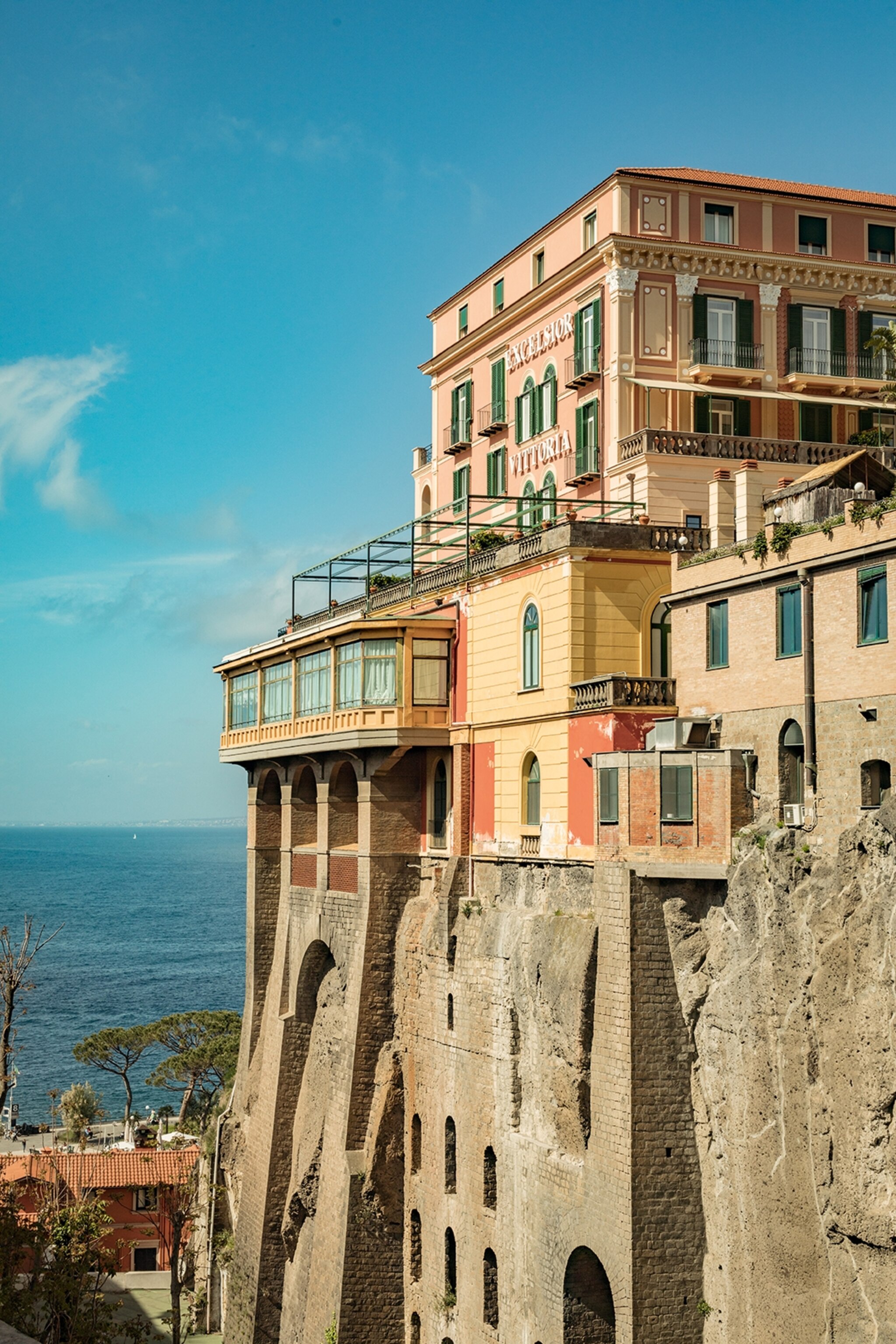 Coloured building on a cliff face overlooking the sea