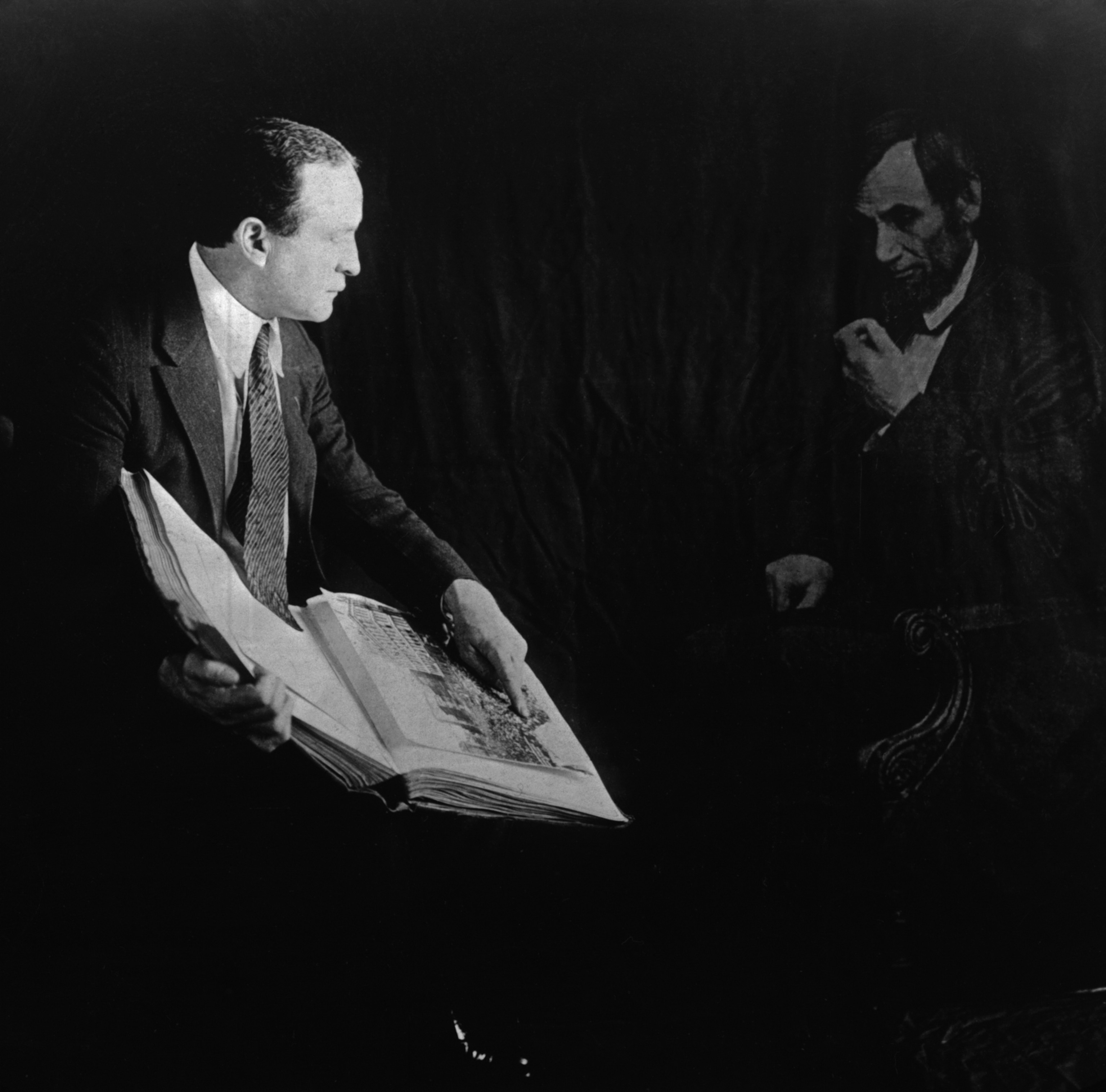 Harry Houdini showing a book to an image of Abraham Lincoln.