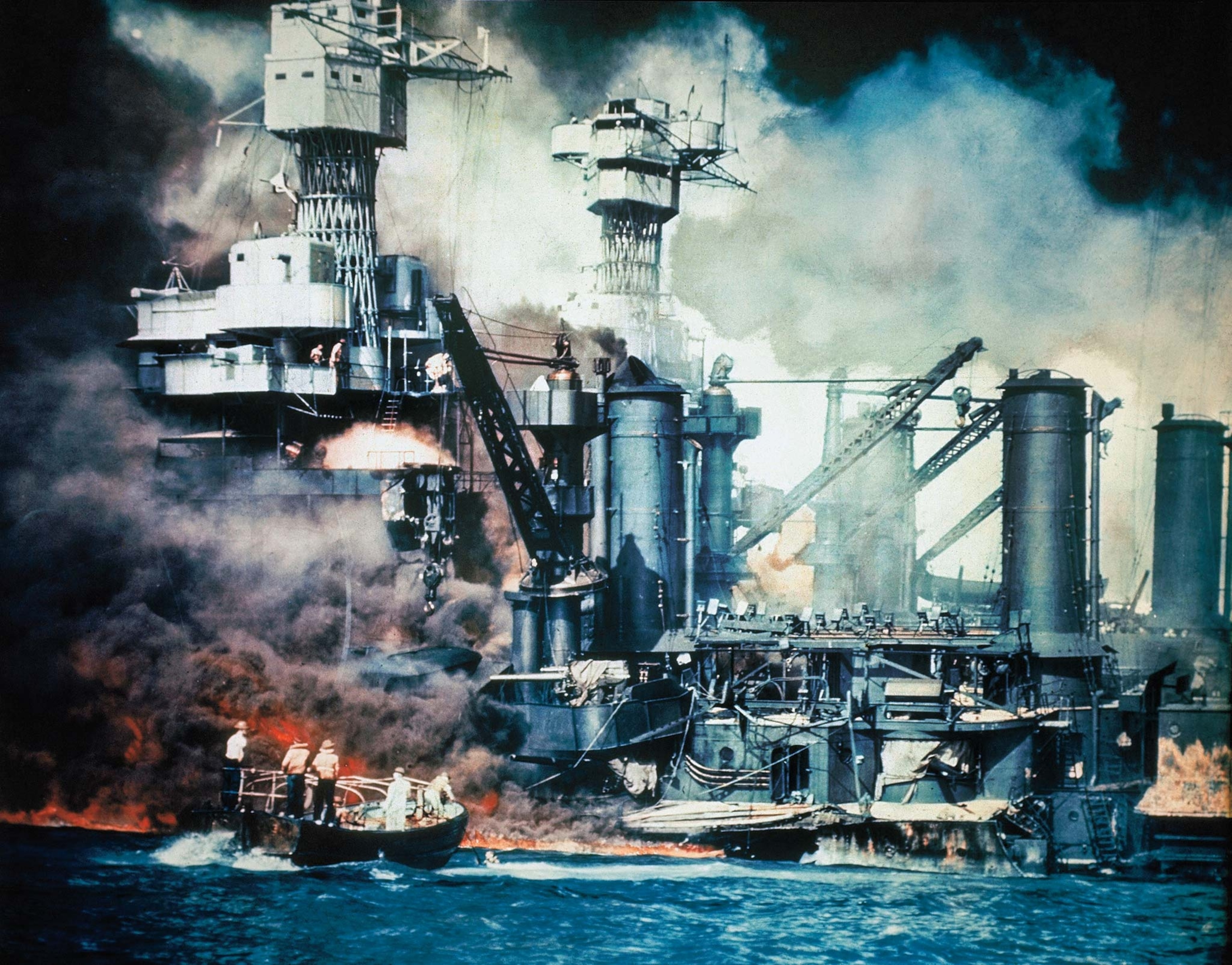 Rescuers pull a crewman from Pearl Harbor as the battleship U.S.S. West Virginia burns.