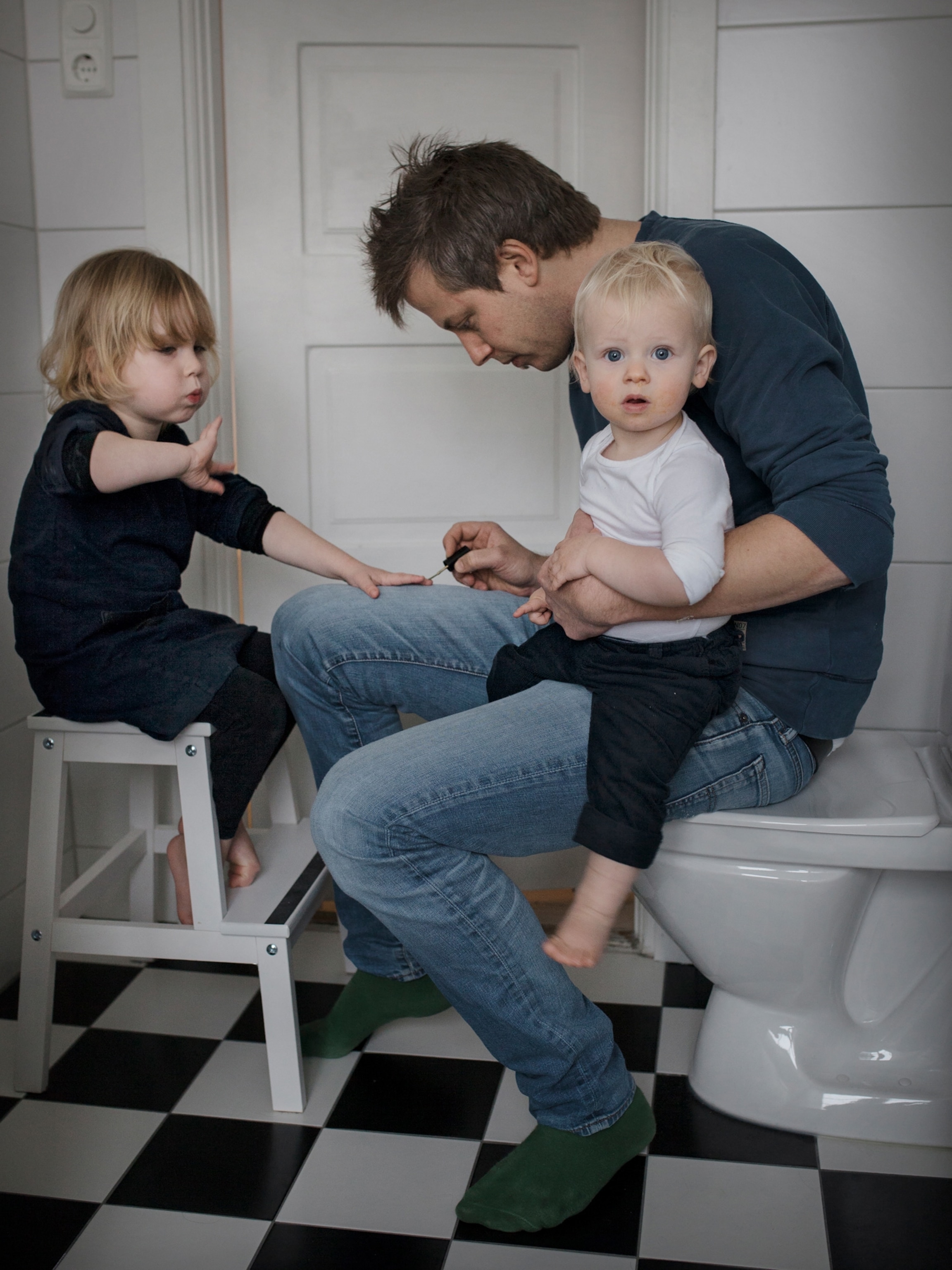 a father painting his daughter's finger nails