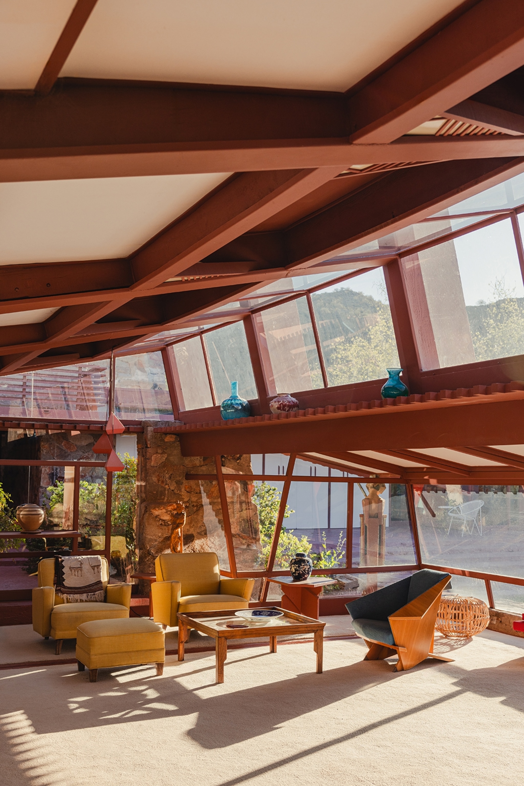 Light floods into an expansive living room in Arizona. Windows line the top and bottom of the walls, whilst the ceiling slants across.
