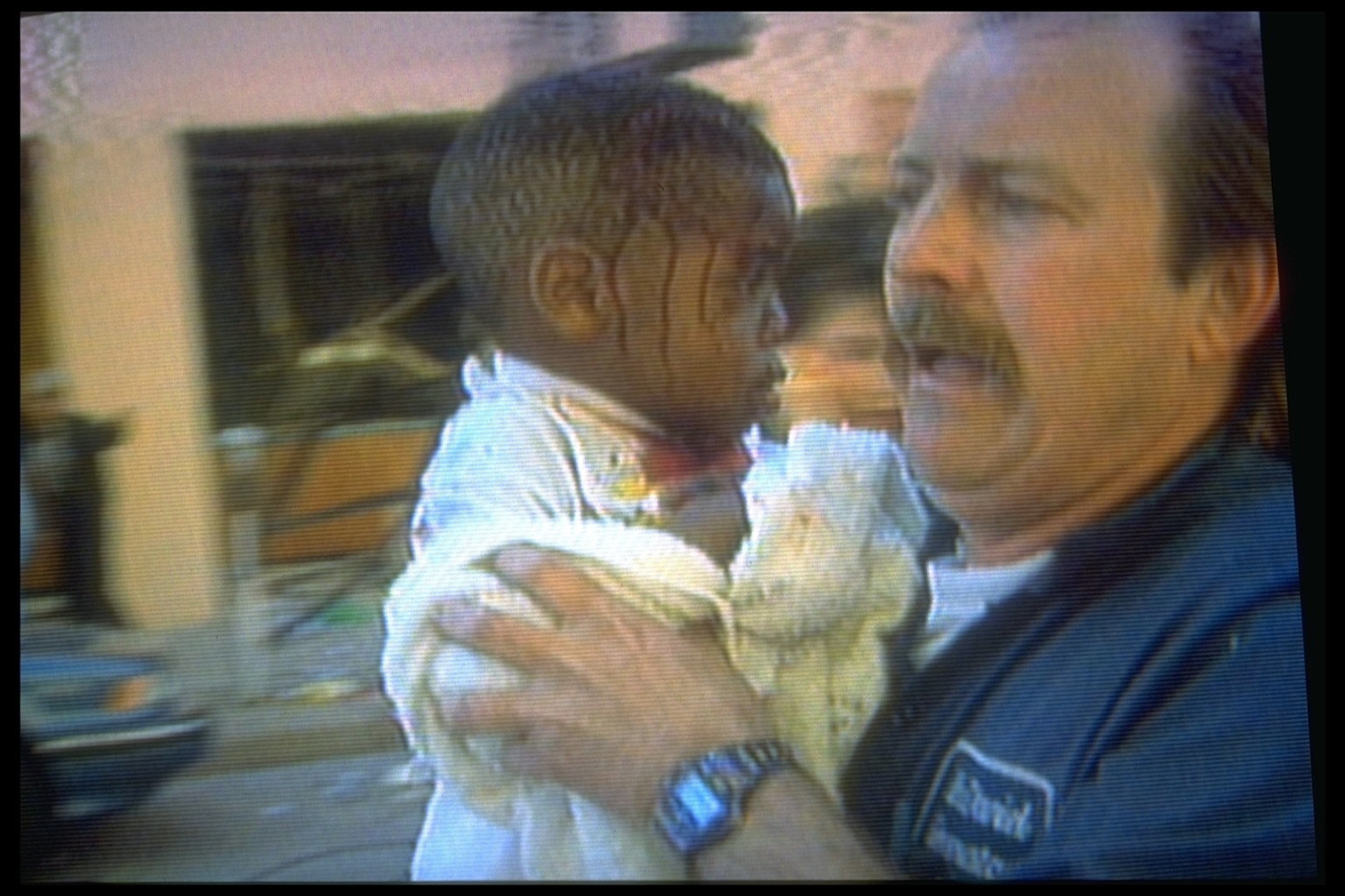 A man frantically runs while carrying a child with a bleeding head.