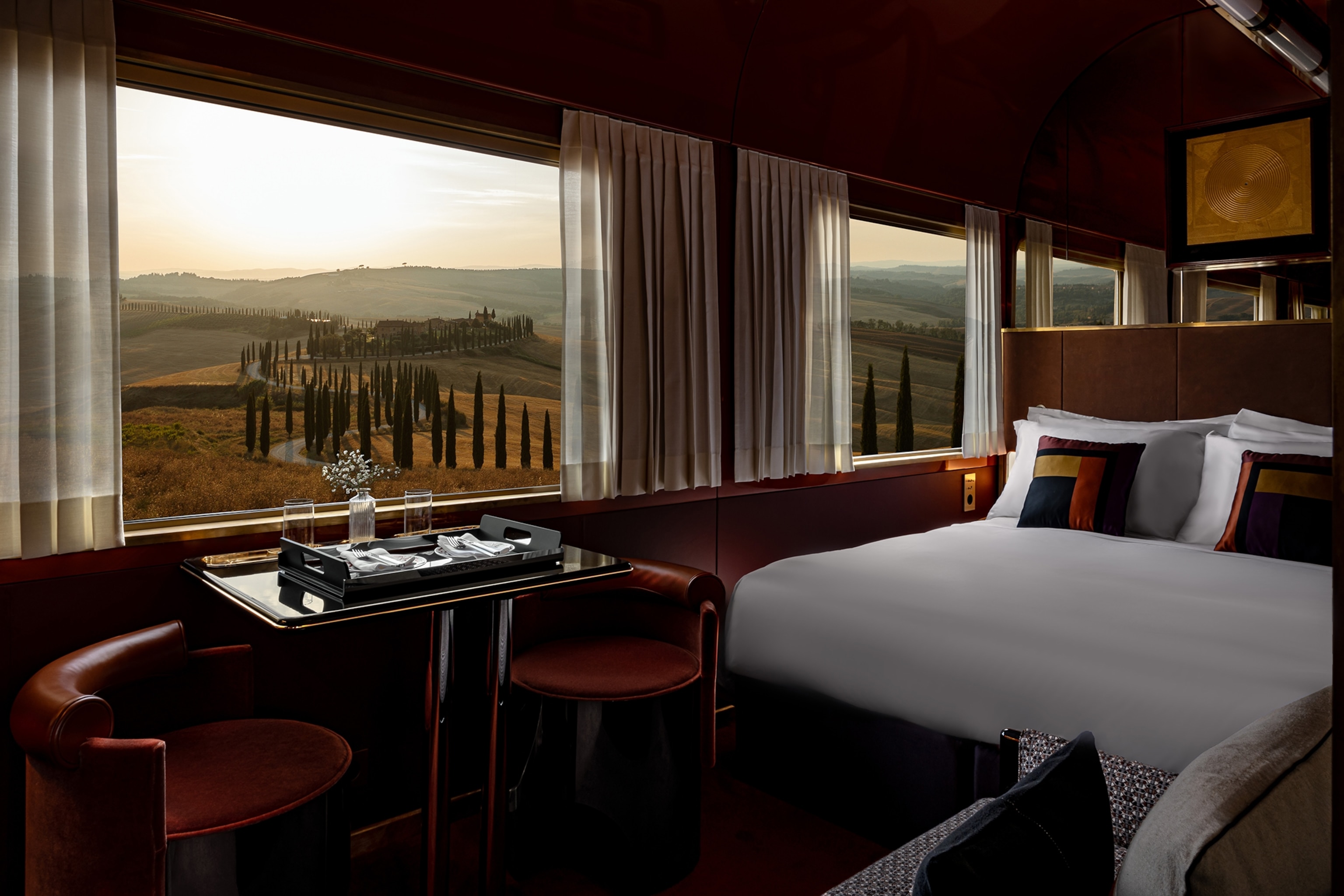 A look inside a train bedroom with a view on cypresses.