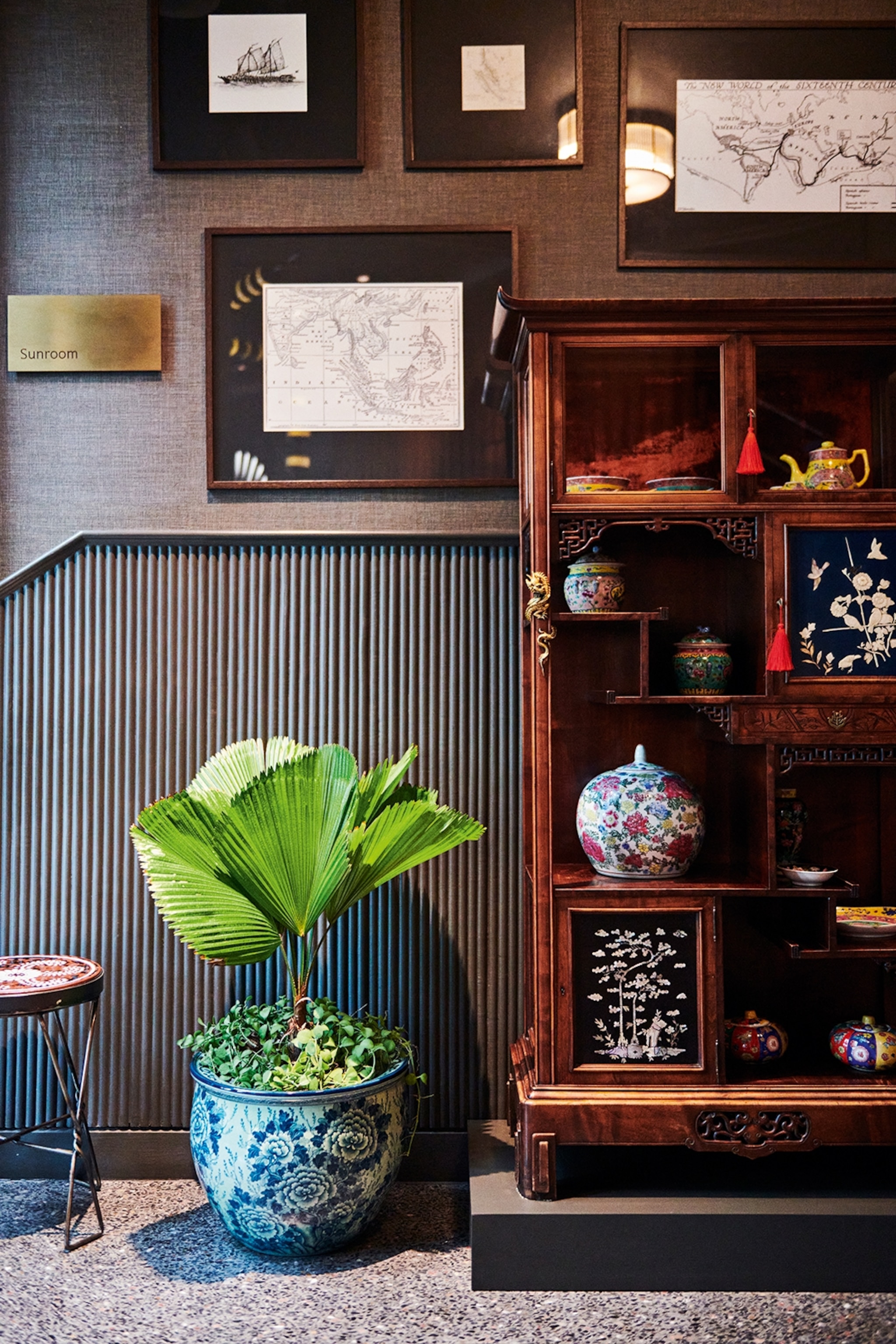 A hotel lobby in Phuket, Thailand with traditional artifacts and pictures in wooden frames on the wall