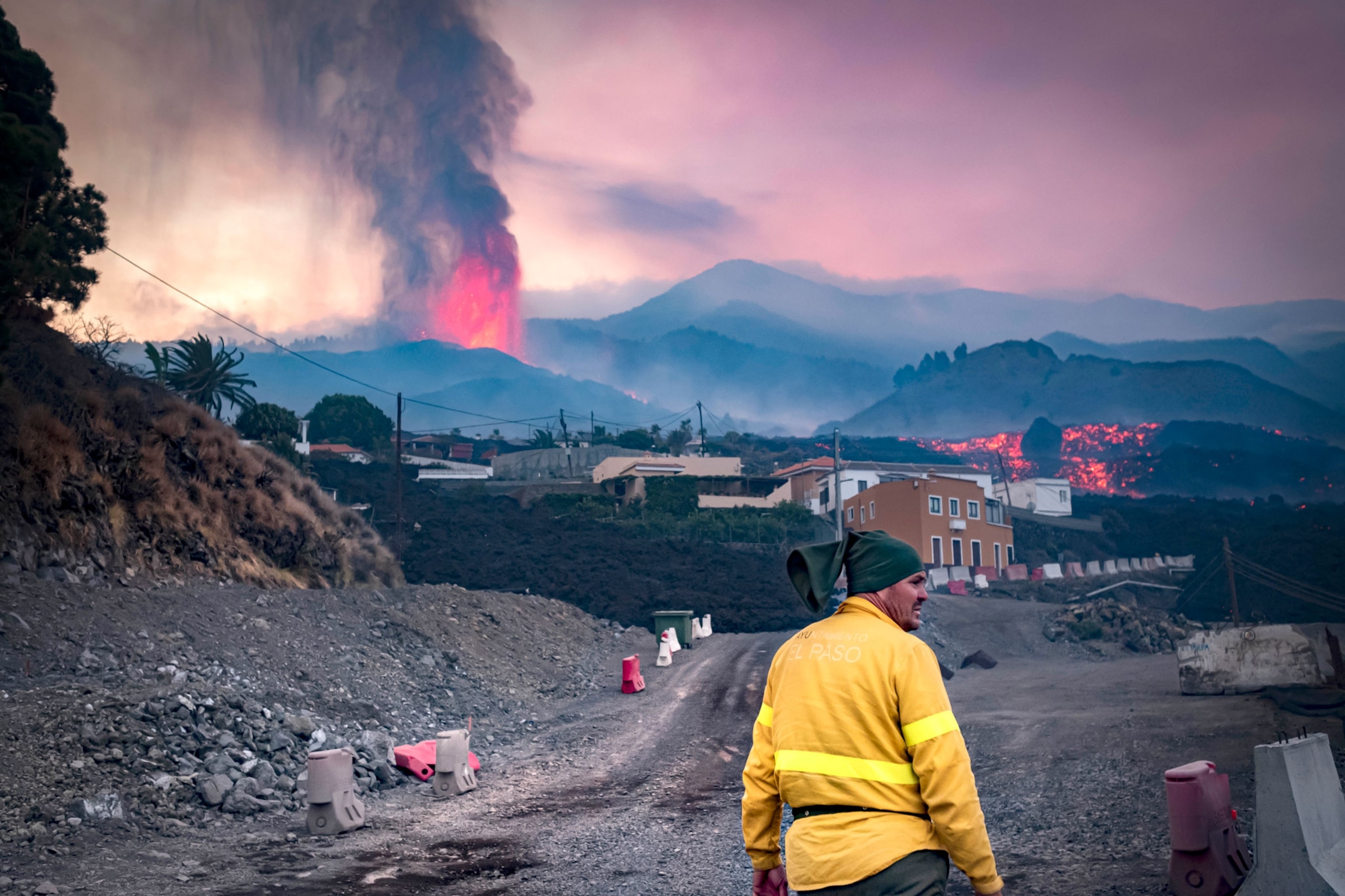 A firefighter stands in the view of the eruption.