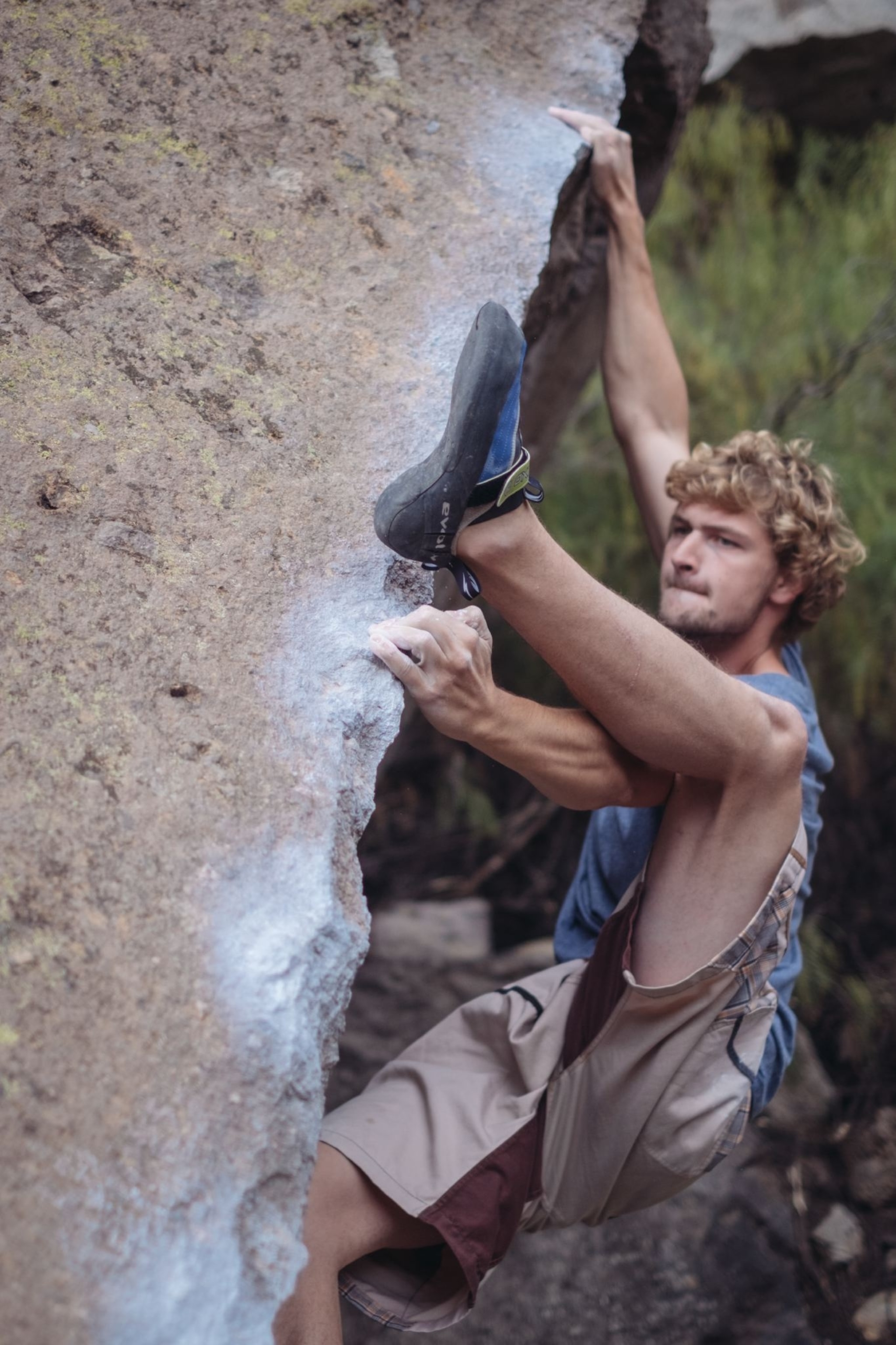 Man free climbs the side of a rock formation