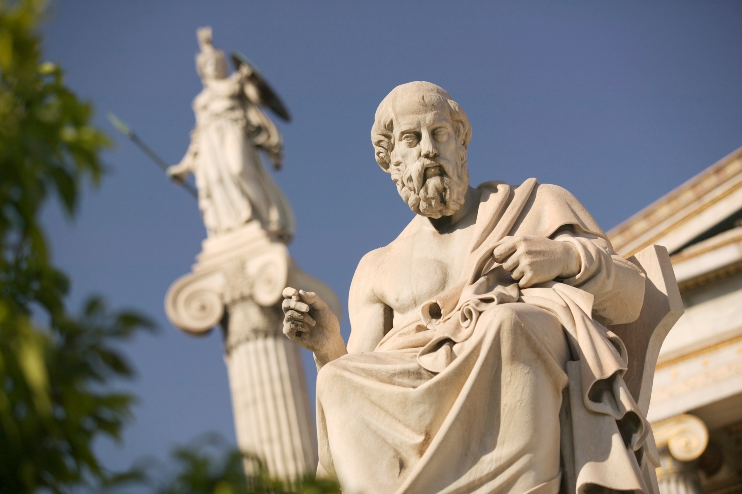 Photo of stone statue of man with beard against blue sky