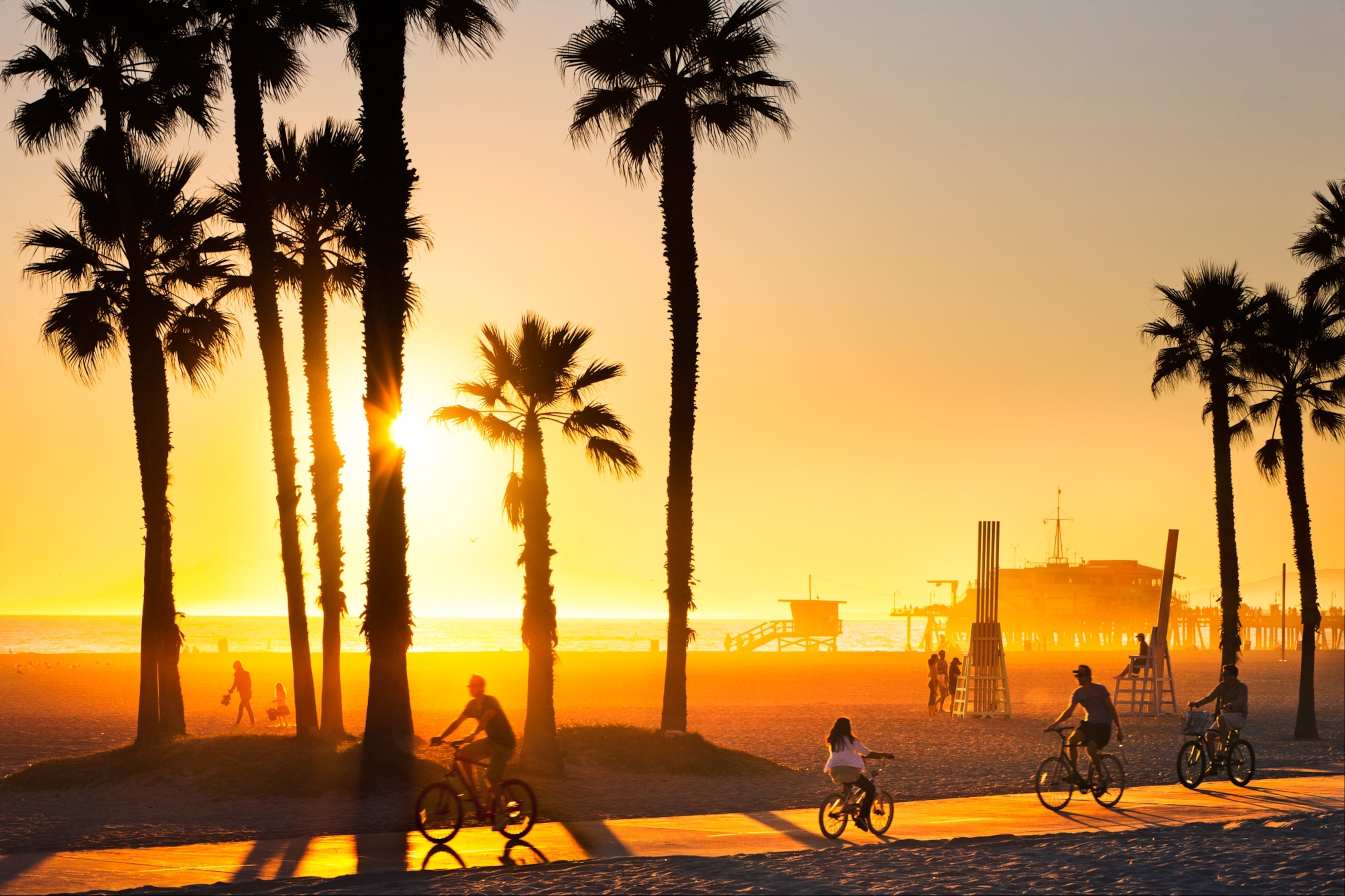 people riding bikes at sunset at Venice Beach, Los Angeles, California