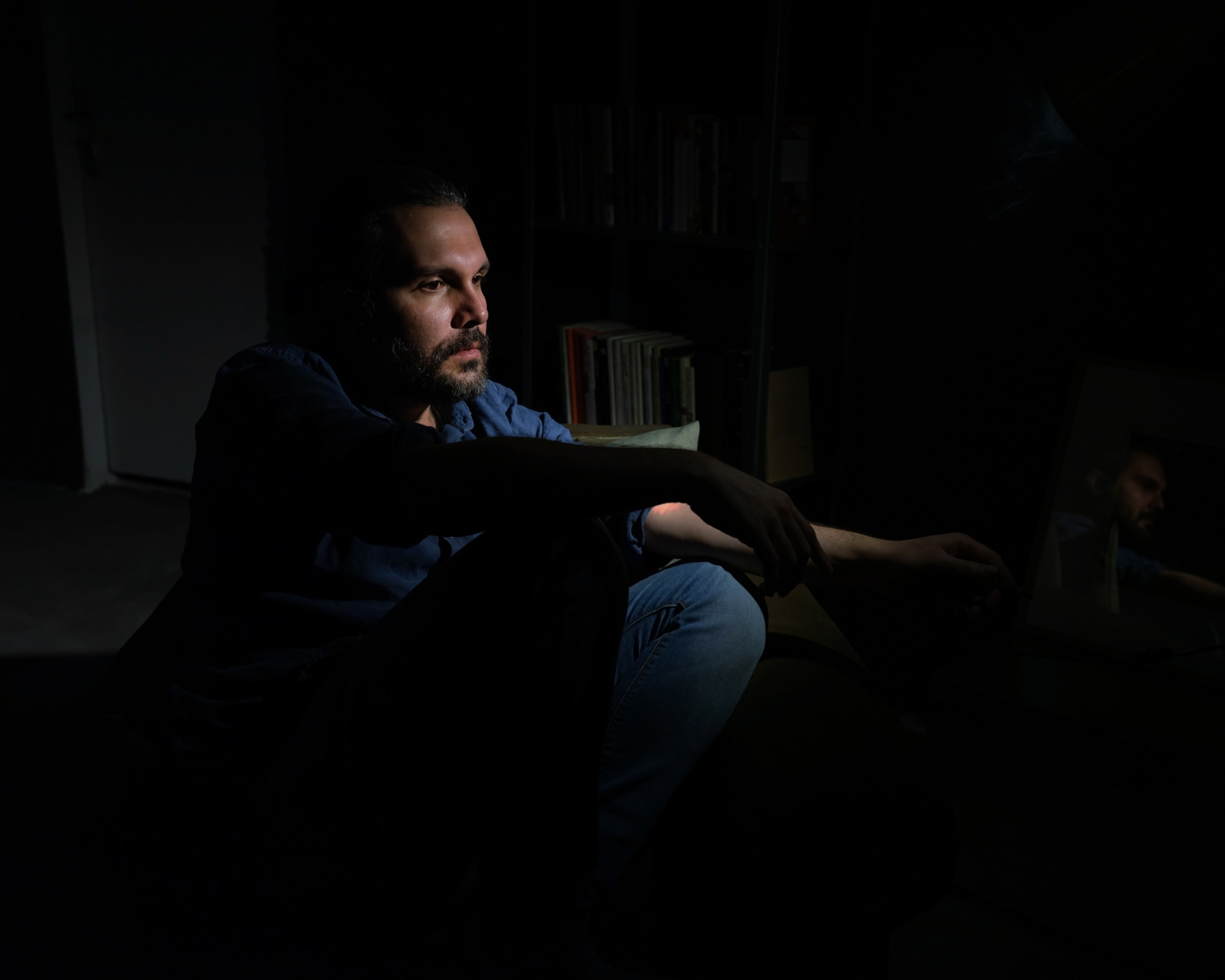 a man sitting on the ground in dim lighting