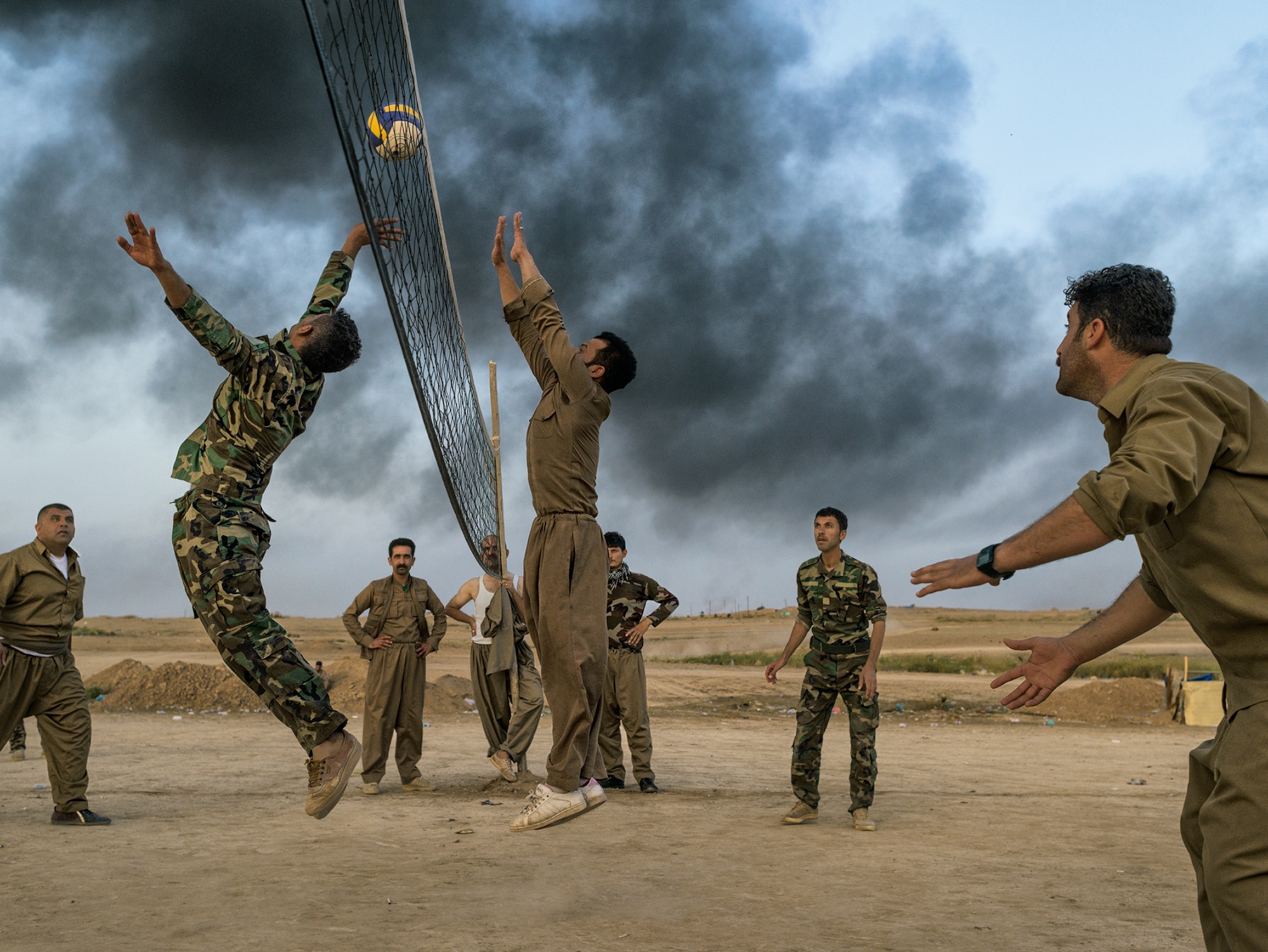 Kurdish peshmerga troops playing volleyball behind the front lines