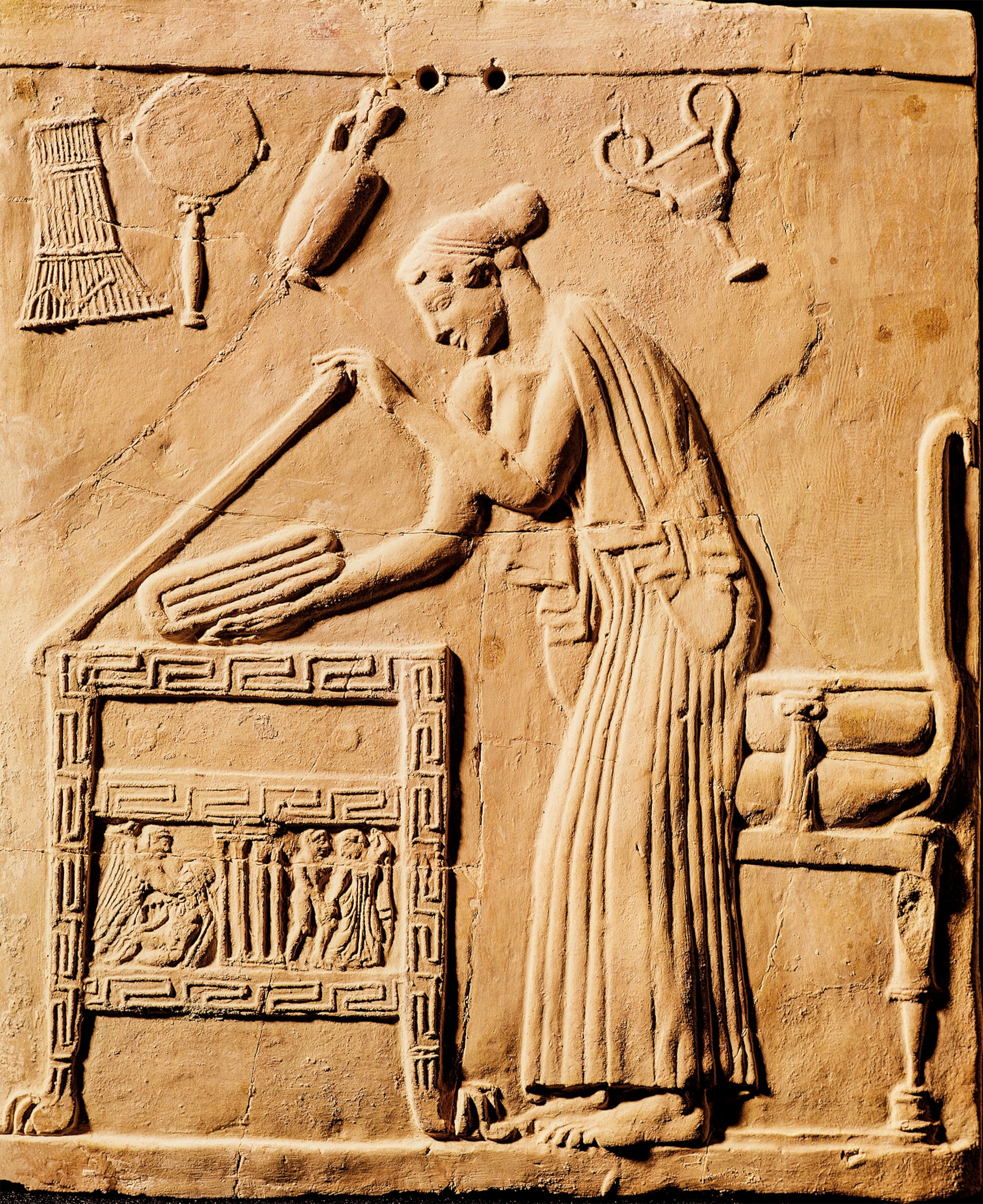 A woman places her robe in a chest in a fifth century B.C. Greek relief.