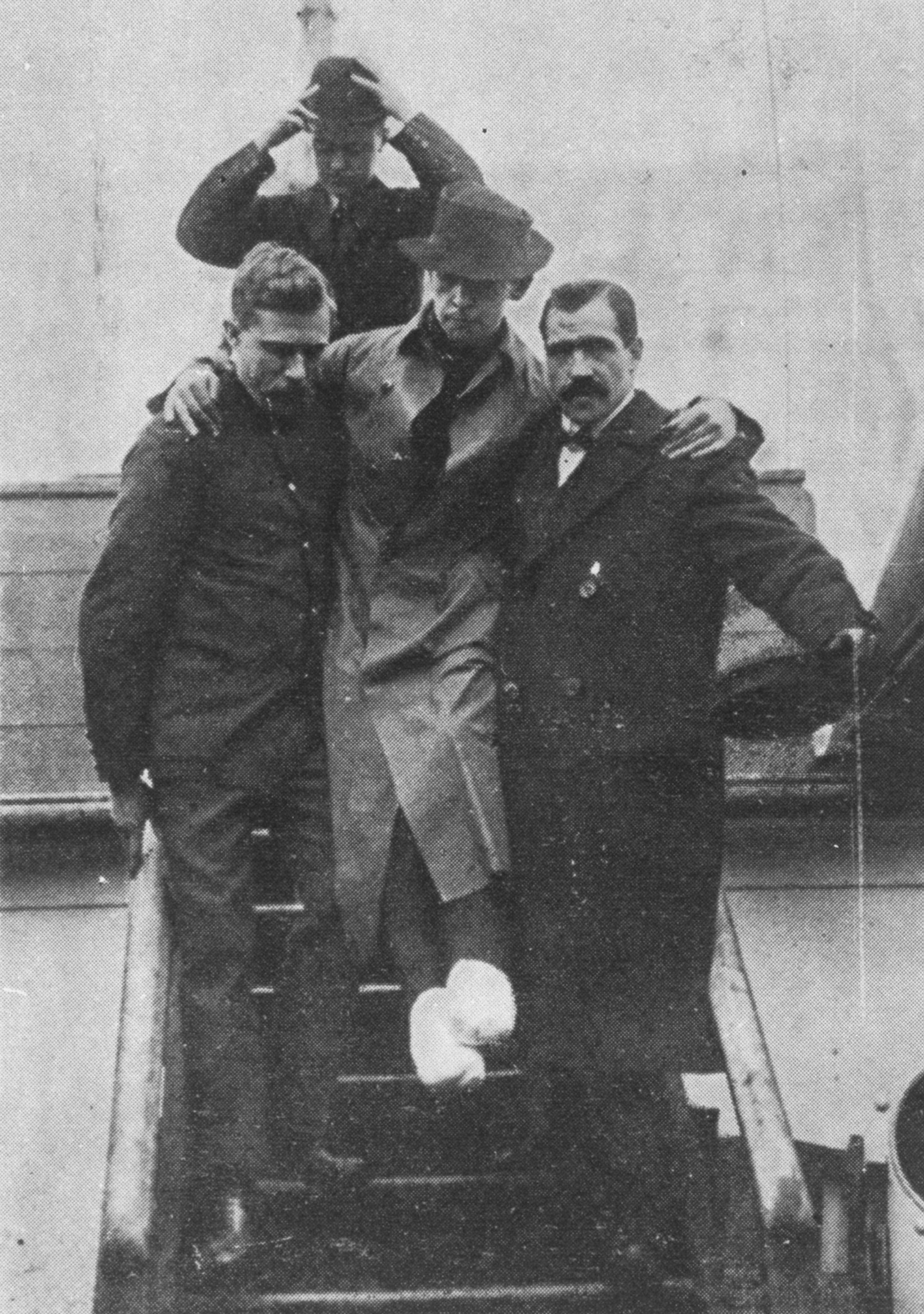 men helping a man off a boat with bandaged feet