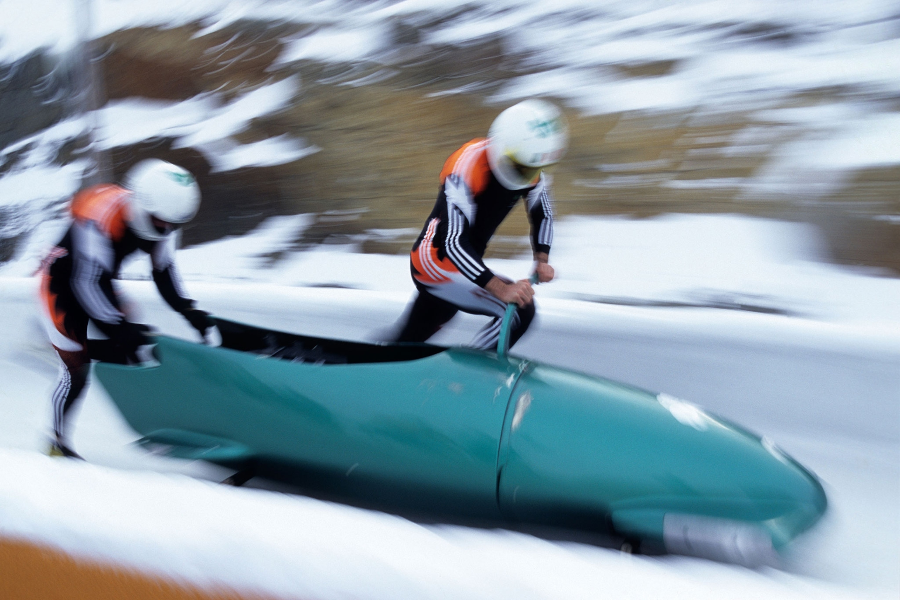 two bob sledders pushing a bob sled