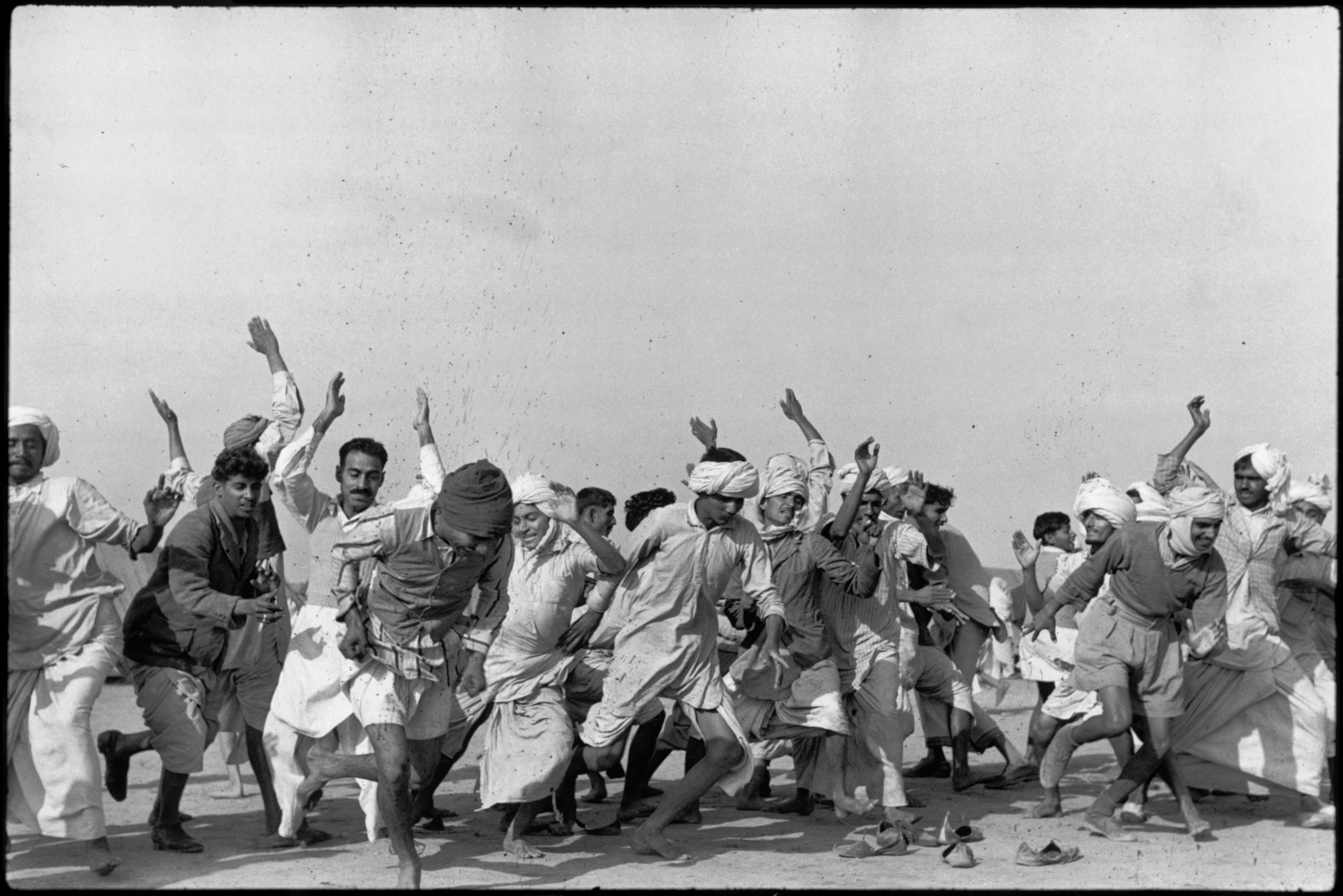 black and white photo of men moving and exercising against white wall
