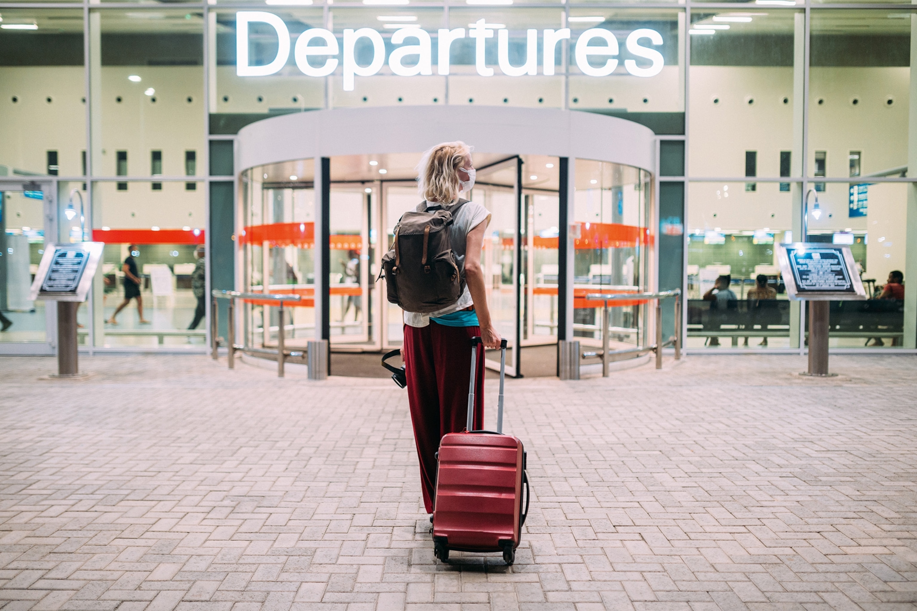 Rear-view of a young woman in front of the airport.