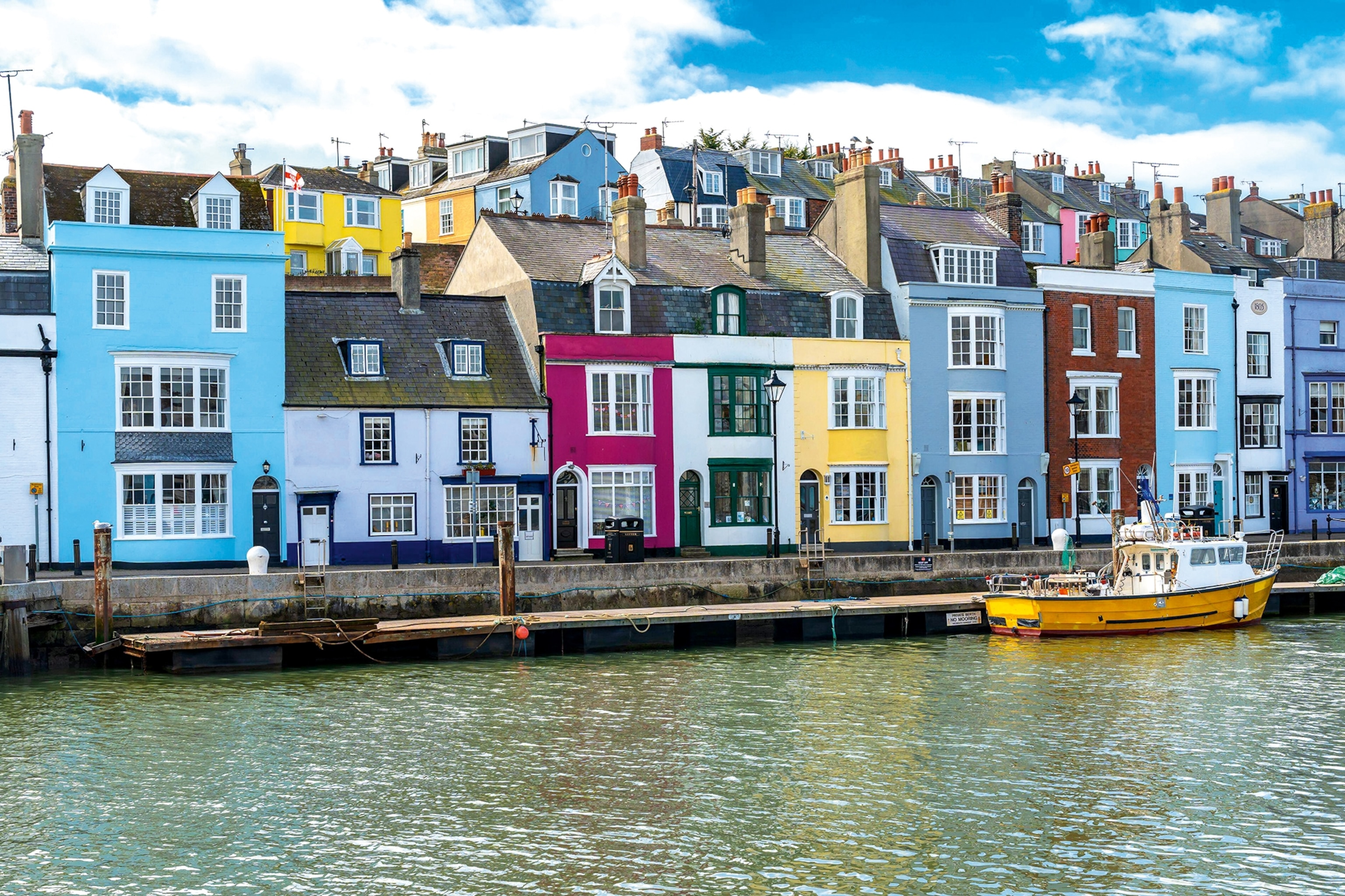 Pastel coloured houses lined up on a harbour front