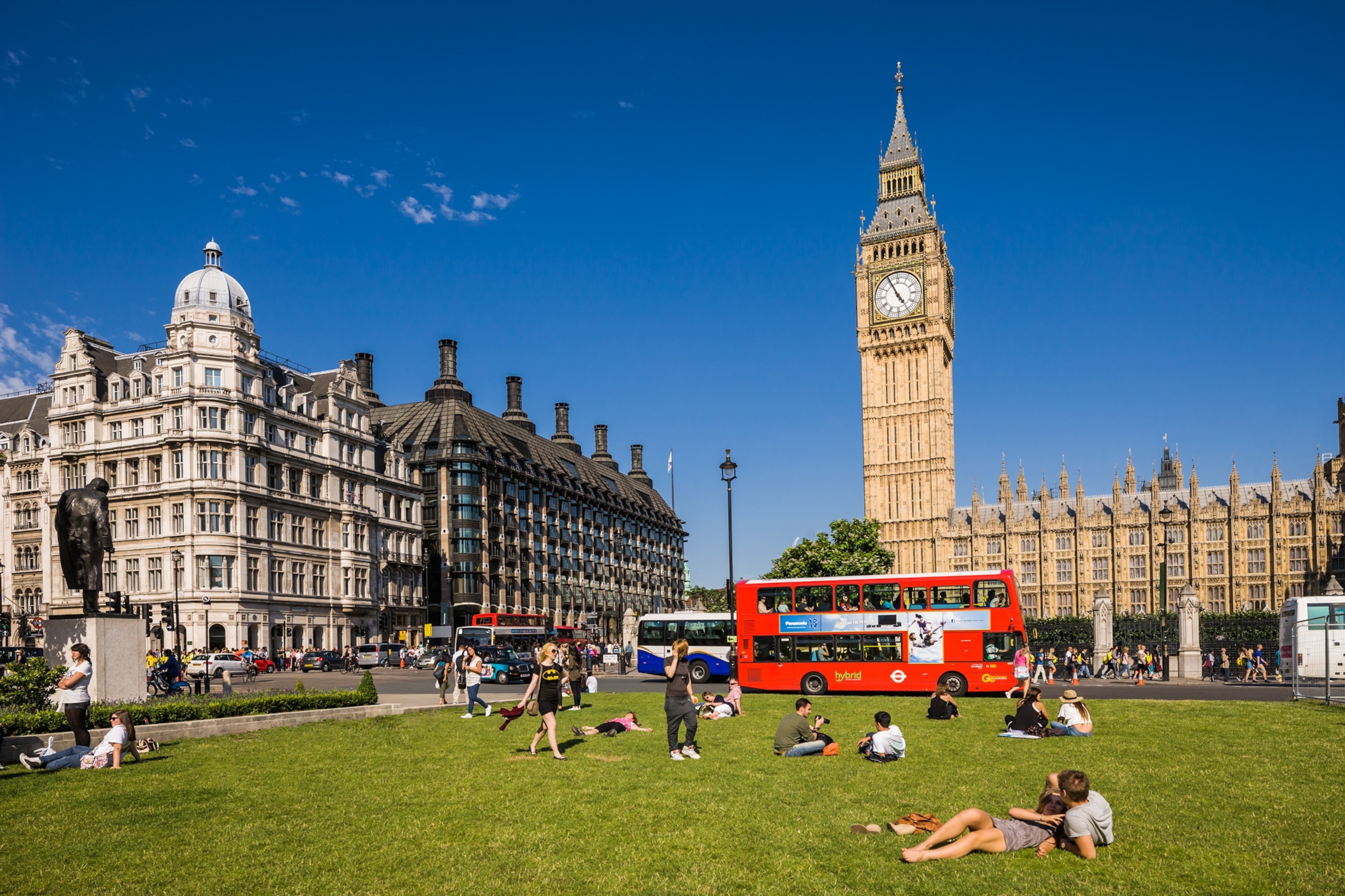people sitting in a park with Big Ben in background, London, England