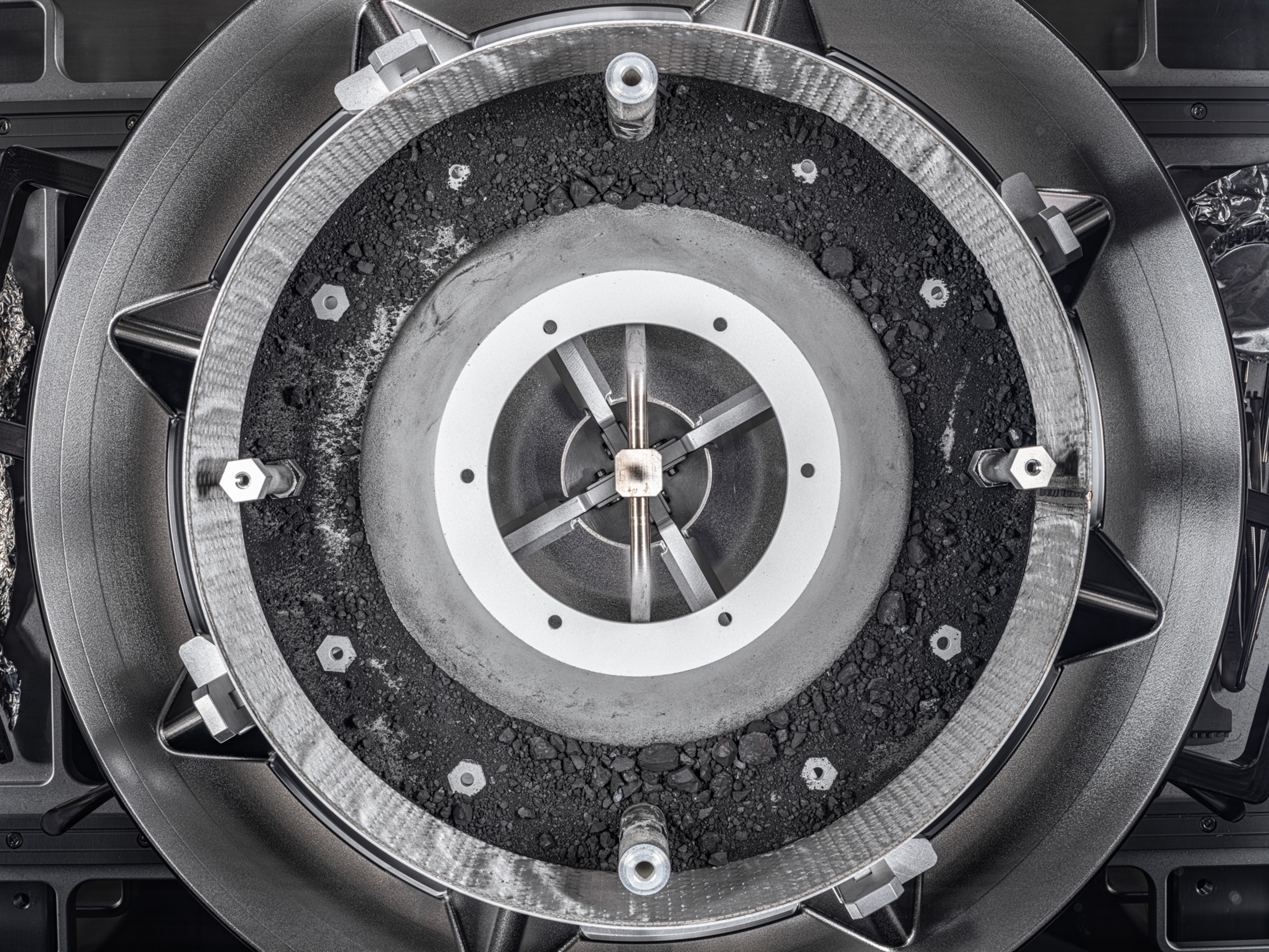 A round metallic tray container black asteroid samples