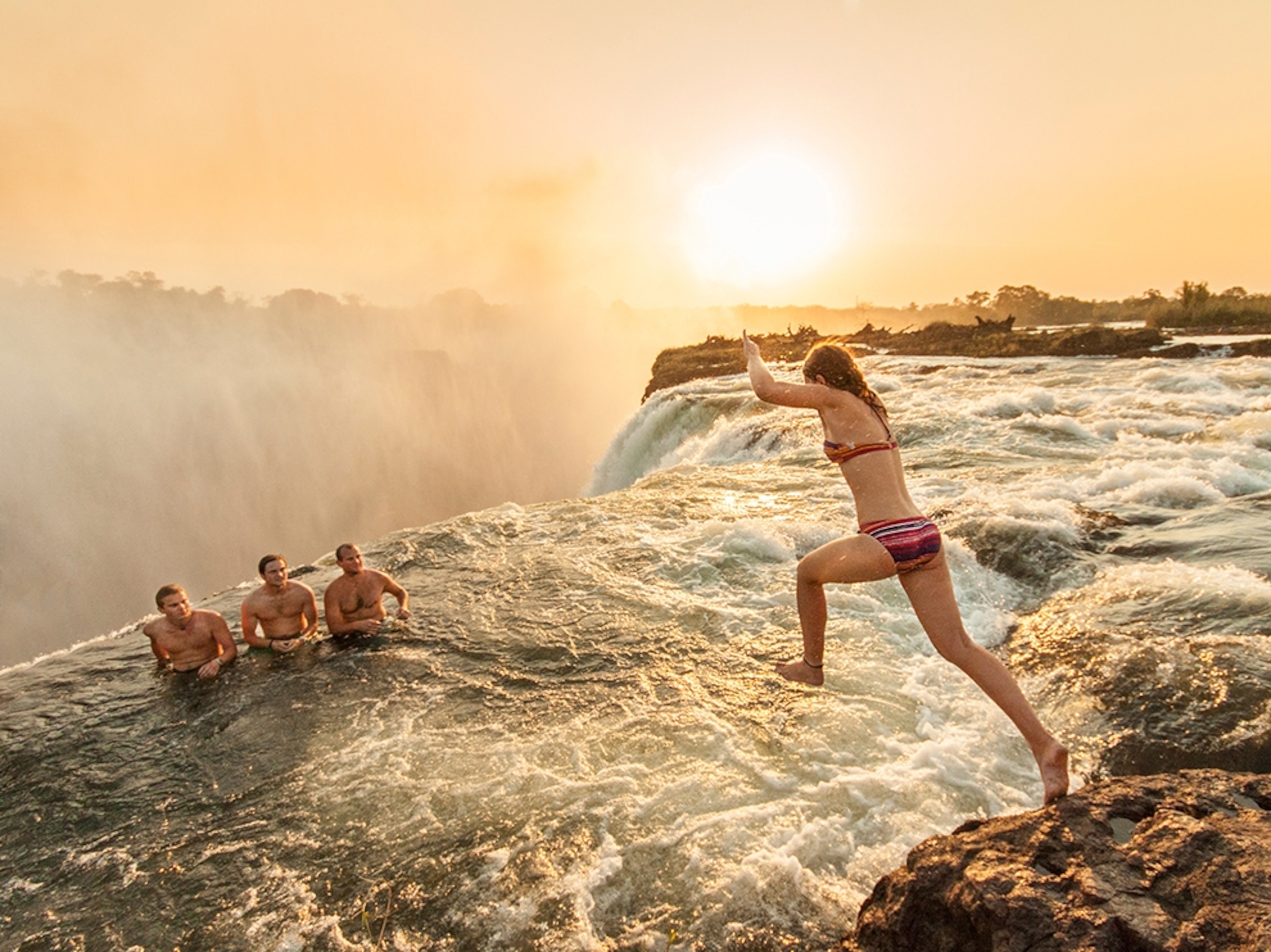 swimmers in Devil's Pool at Victoria Falls