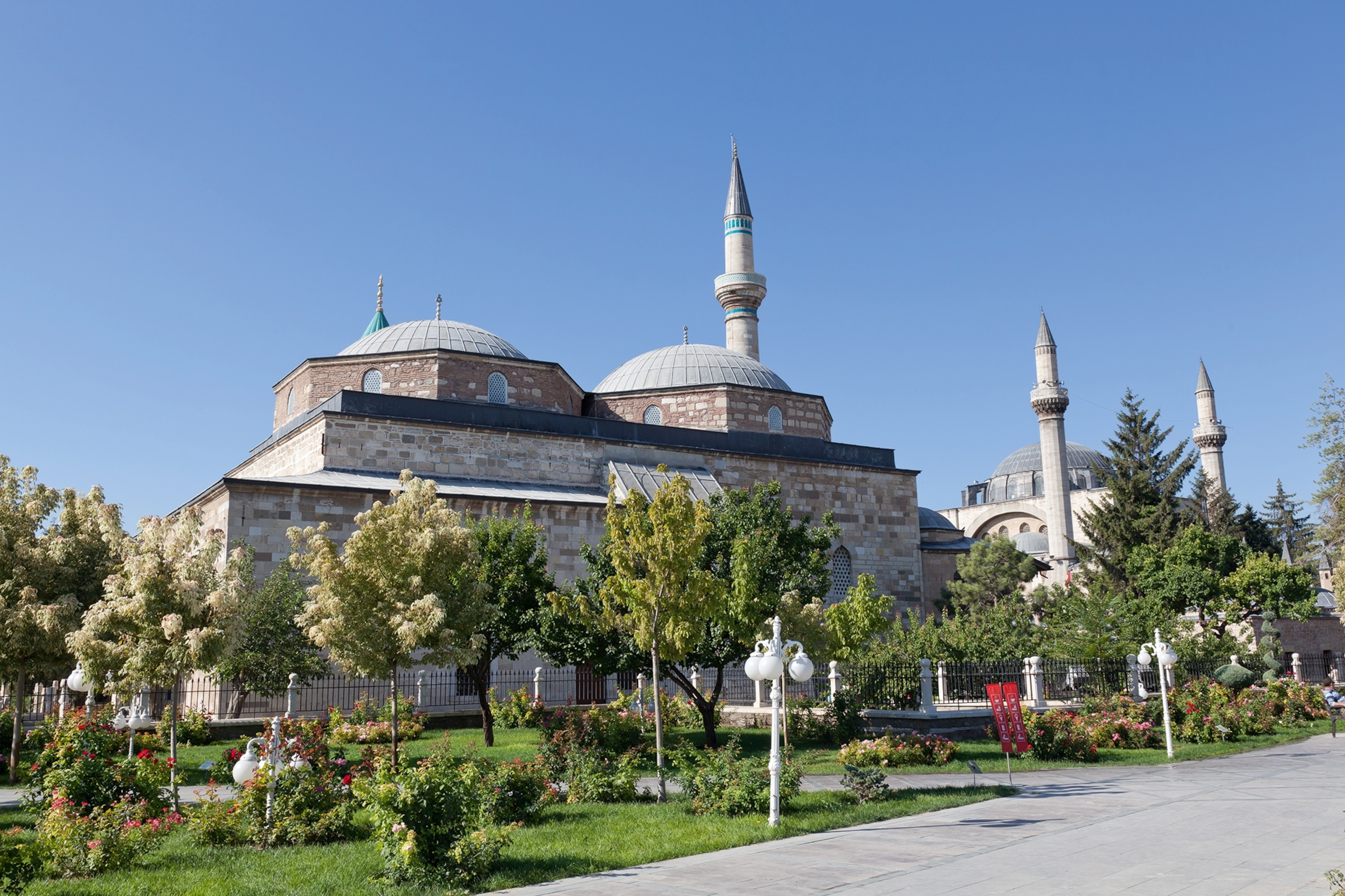 Exterior of a museum with turrets and domes surrounded by trees and grass