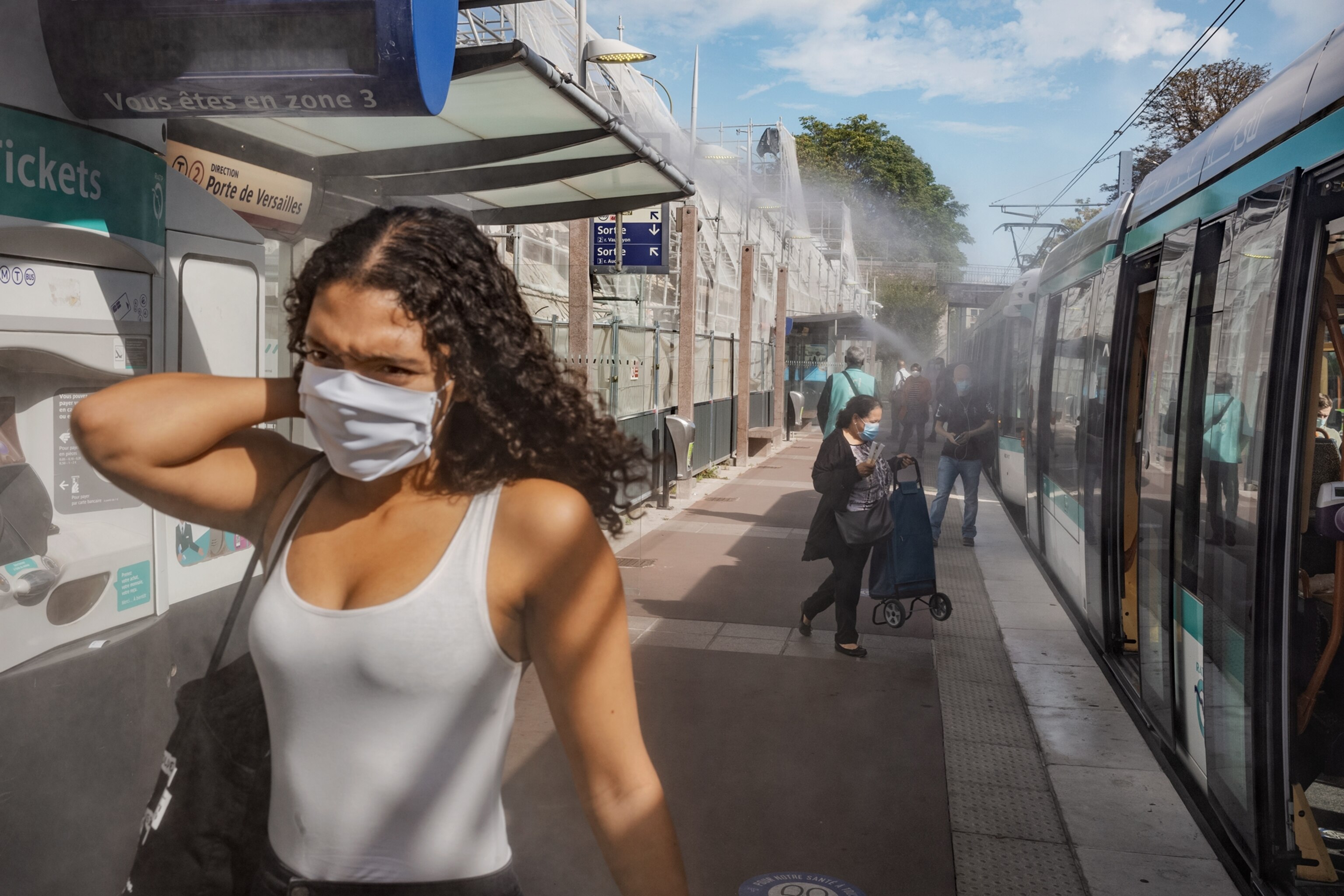 Picture of woman in face mask walking on open tram platform
