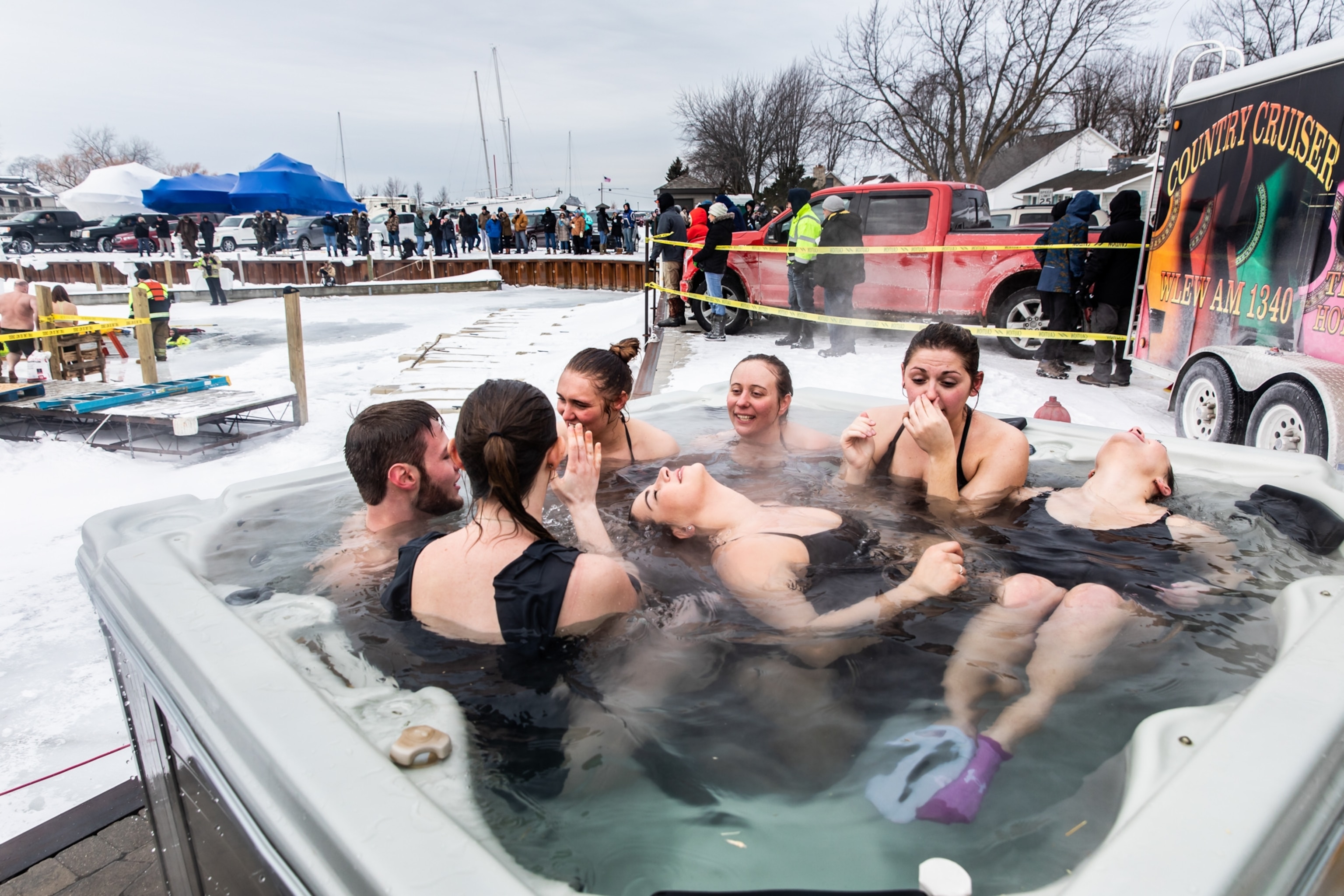 women and a man in a jacuzzi outside during winter