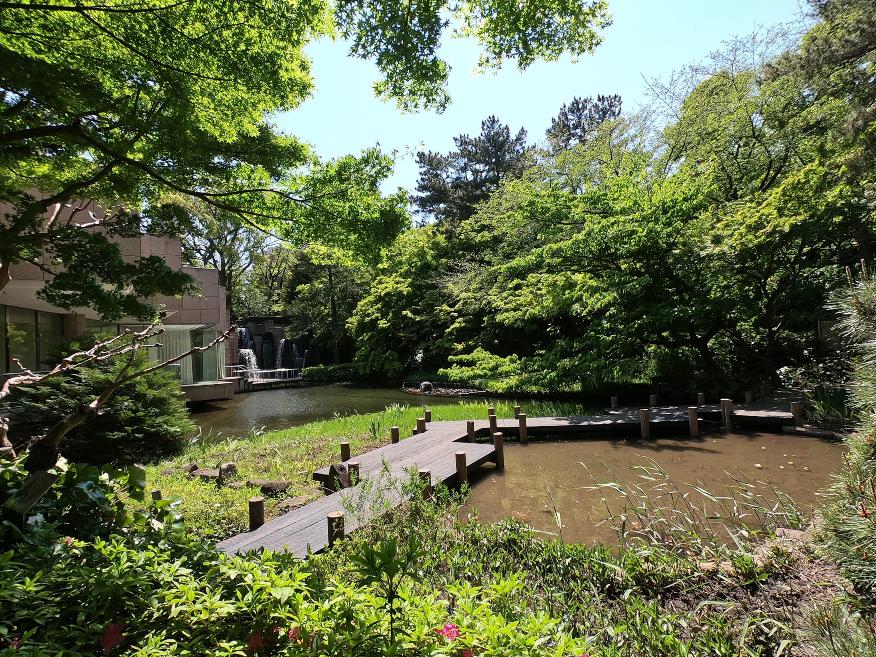 A wide view of a garden in front of a lake.