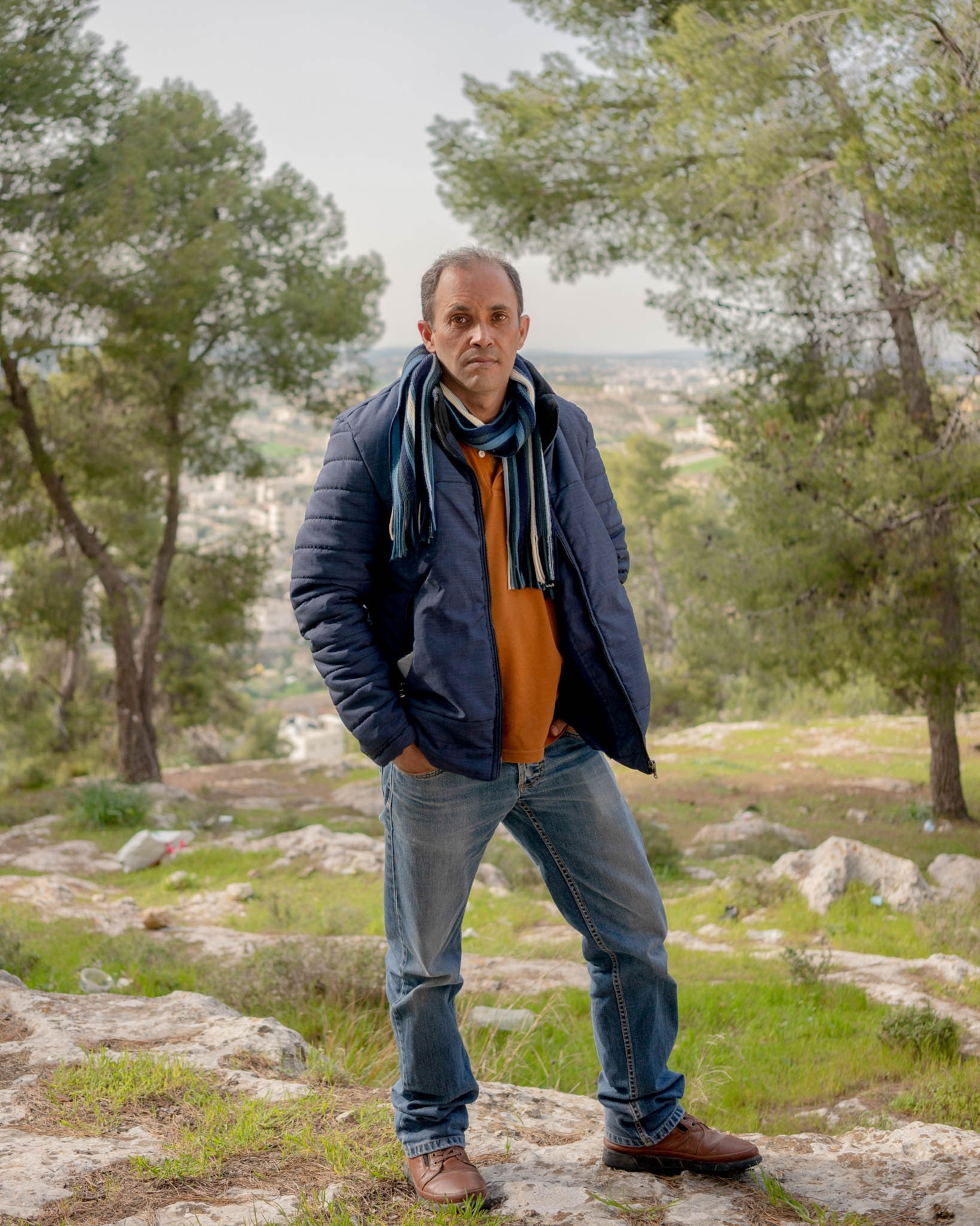 a man poses for a portrait in a forest