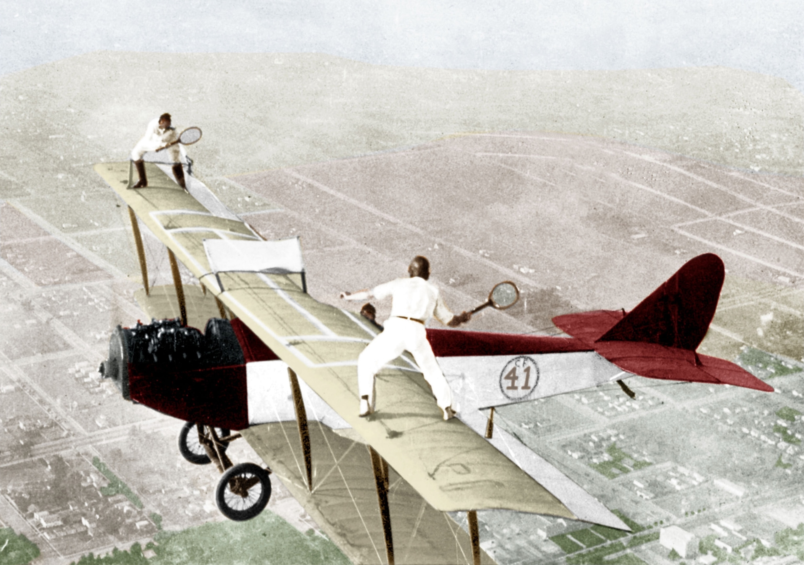 Woman and Man playing tennis on the roof of a a flying plane.