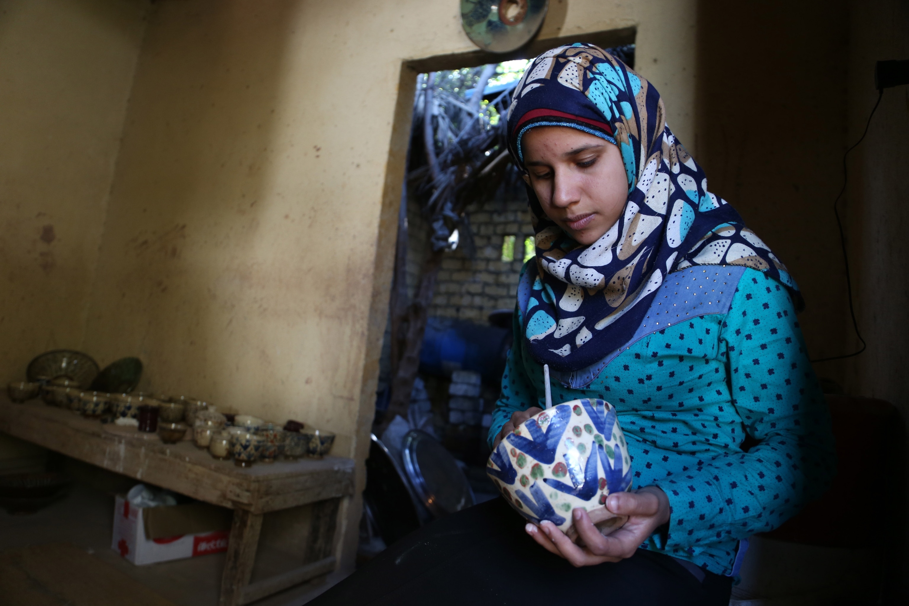 An Egyptian potter makes a piece of pottery work at a workshop in Fayoum