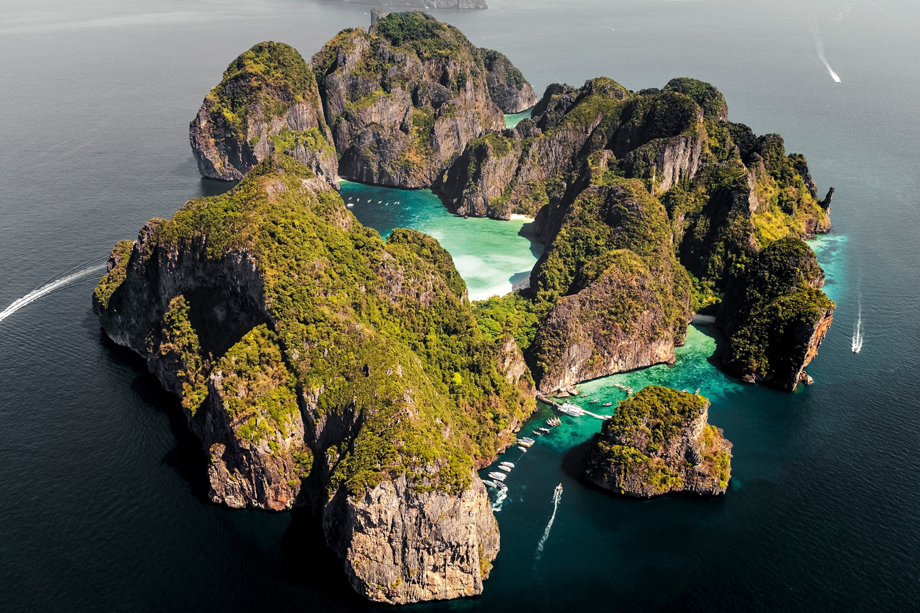 An aerial view of Maya Bay, a cliff-dominated island with a popular sandy beach.