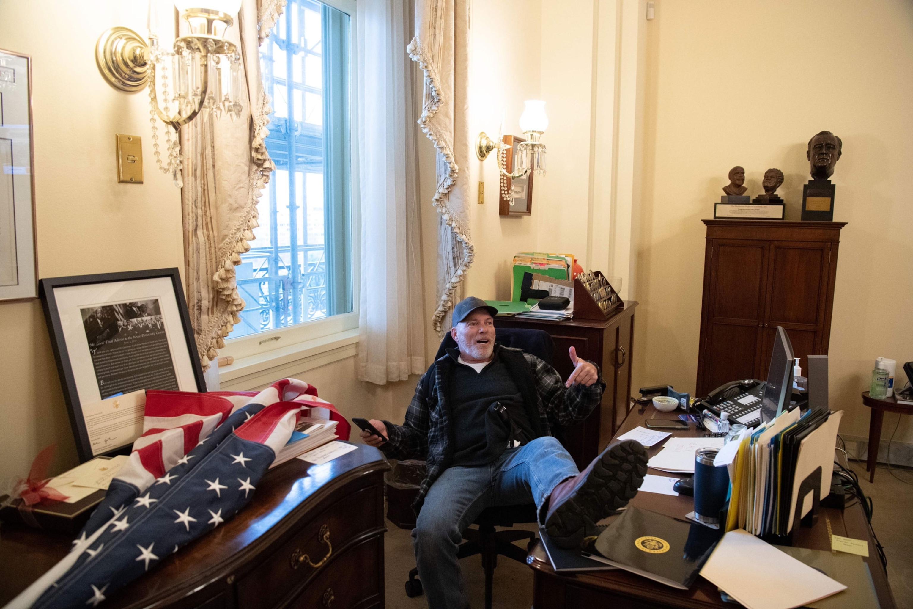 a riotor sitting in Nancy Pelosi's chair