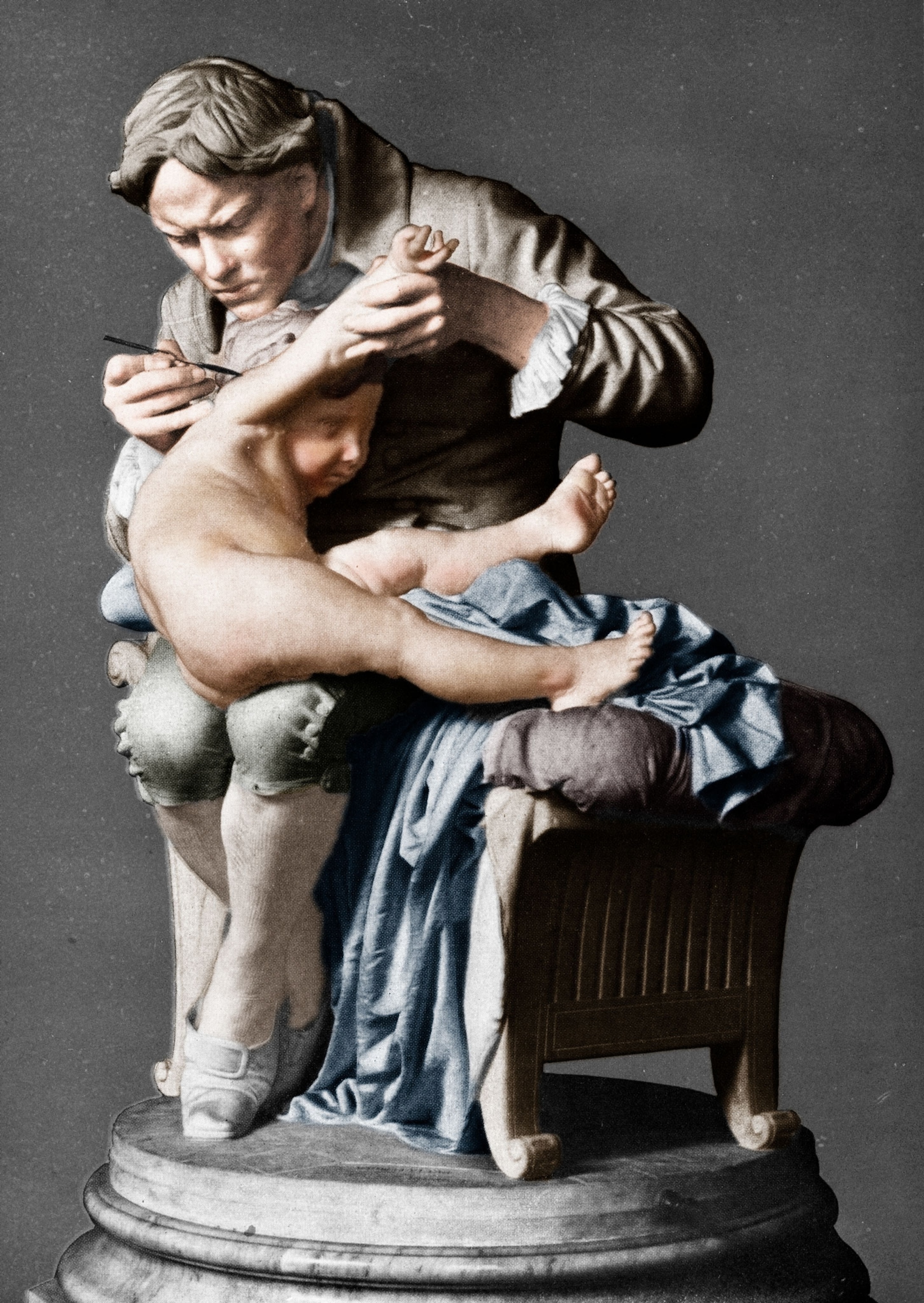 a statue of a physician inoculating a struggling baby