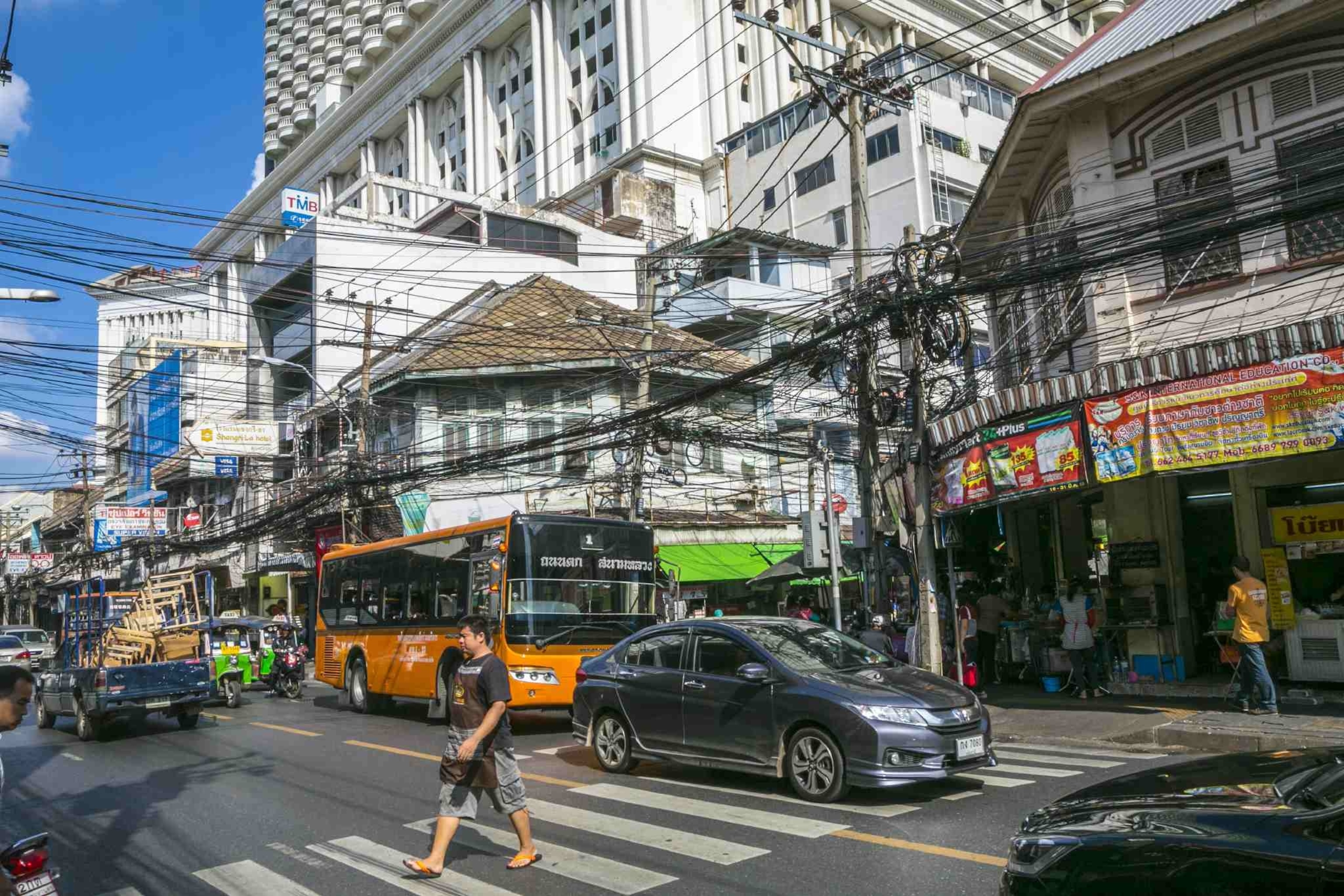 Man crosses a busy street in Bangkok Thailand
