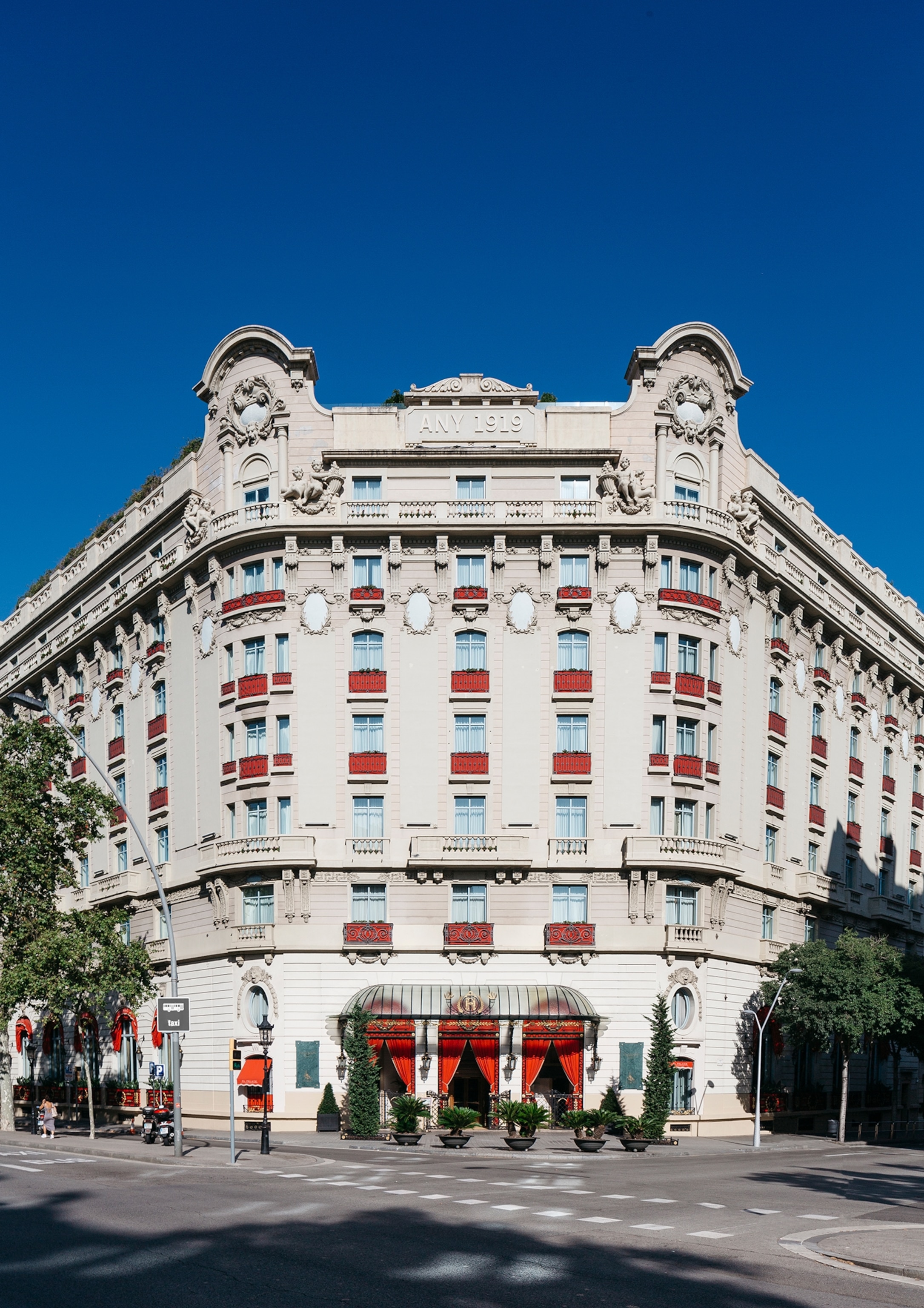 A white hotel with a red awning.