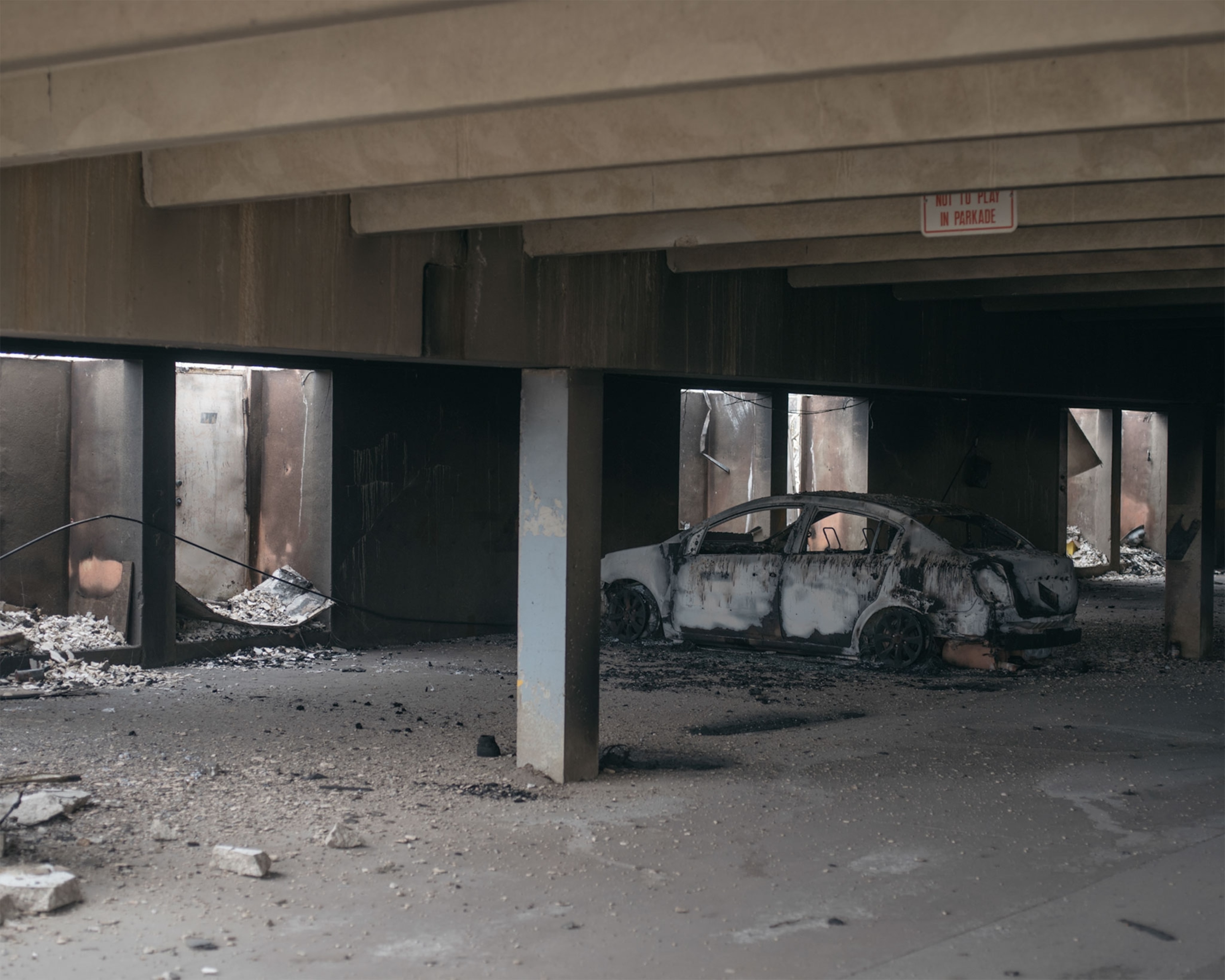a burnt car in a parking garage