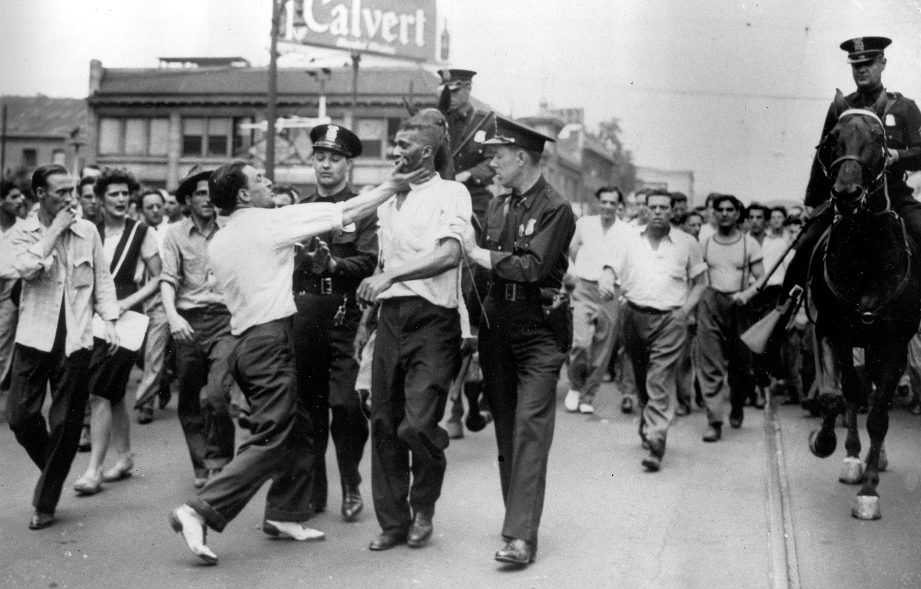 a white man slapping a black man during the detroit riots