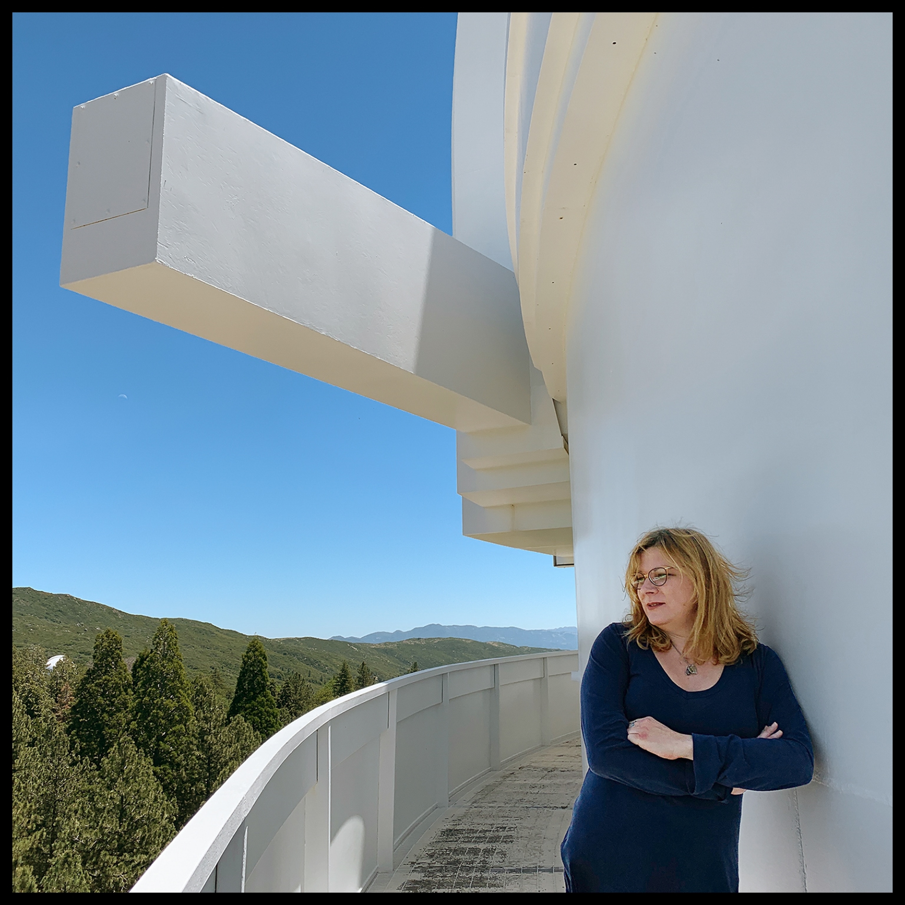 woman standing outdoors on a buildings patio edge