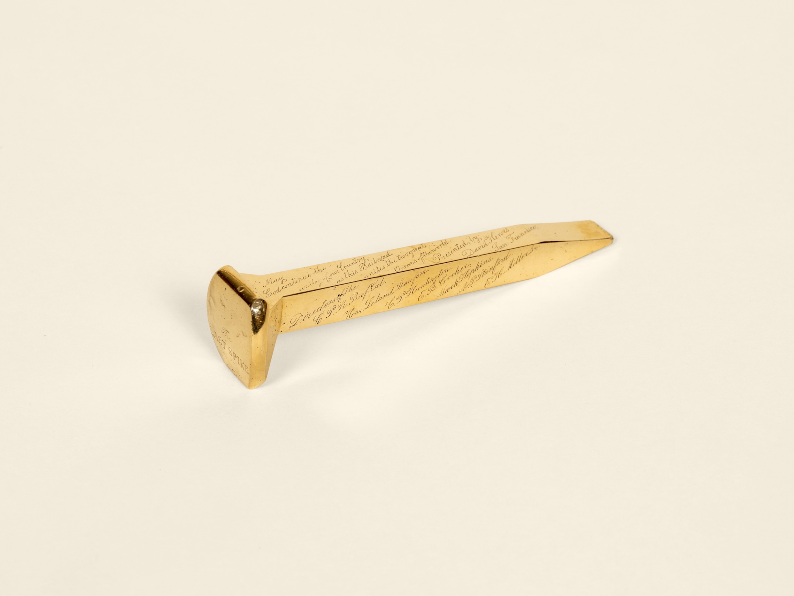 A golden spike with small letters engraved on it