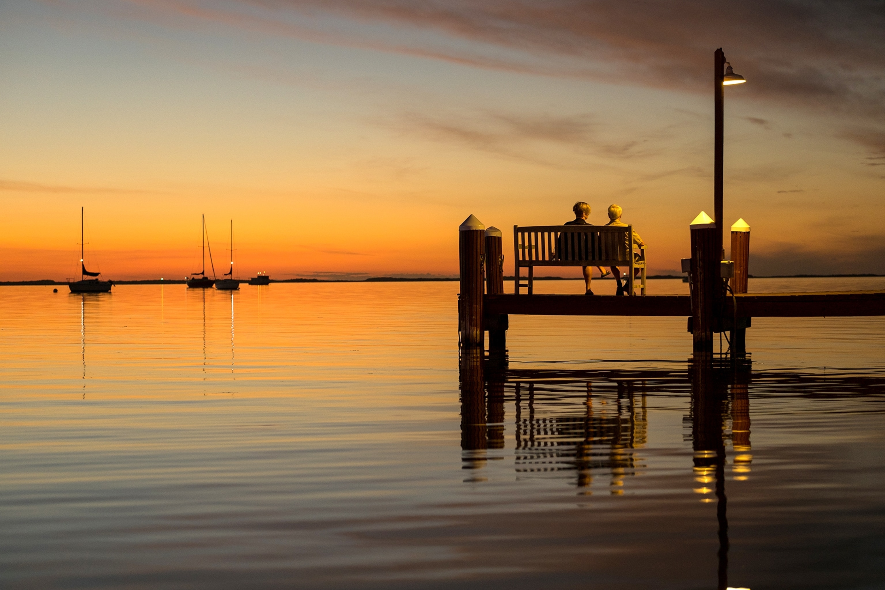 couple sitting on dock watching the sunset in Biscayne National Park, Florida