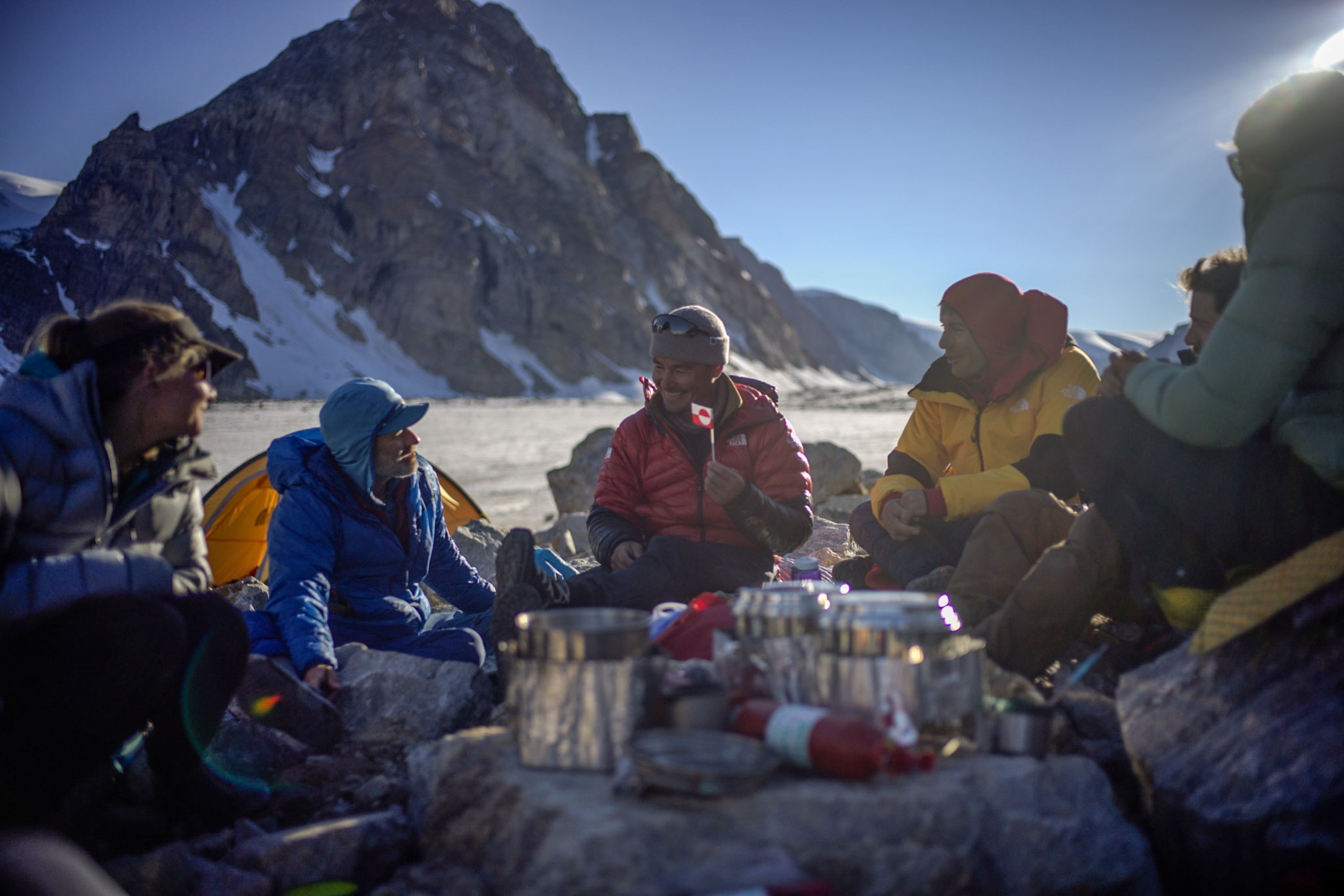 an expedition team eats and talks at their camp in Greenland