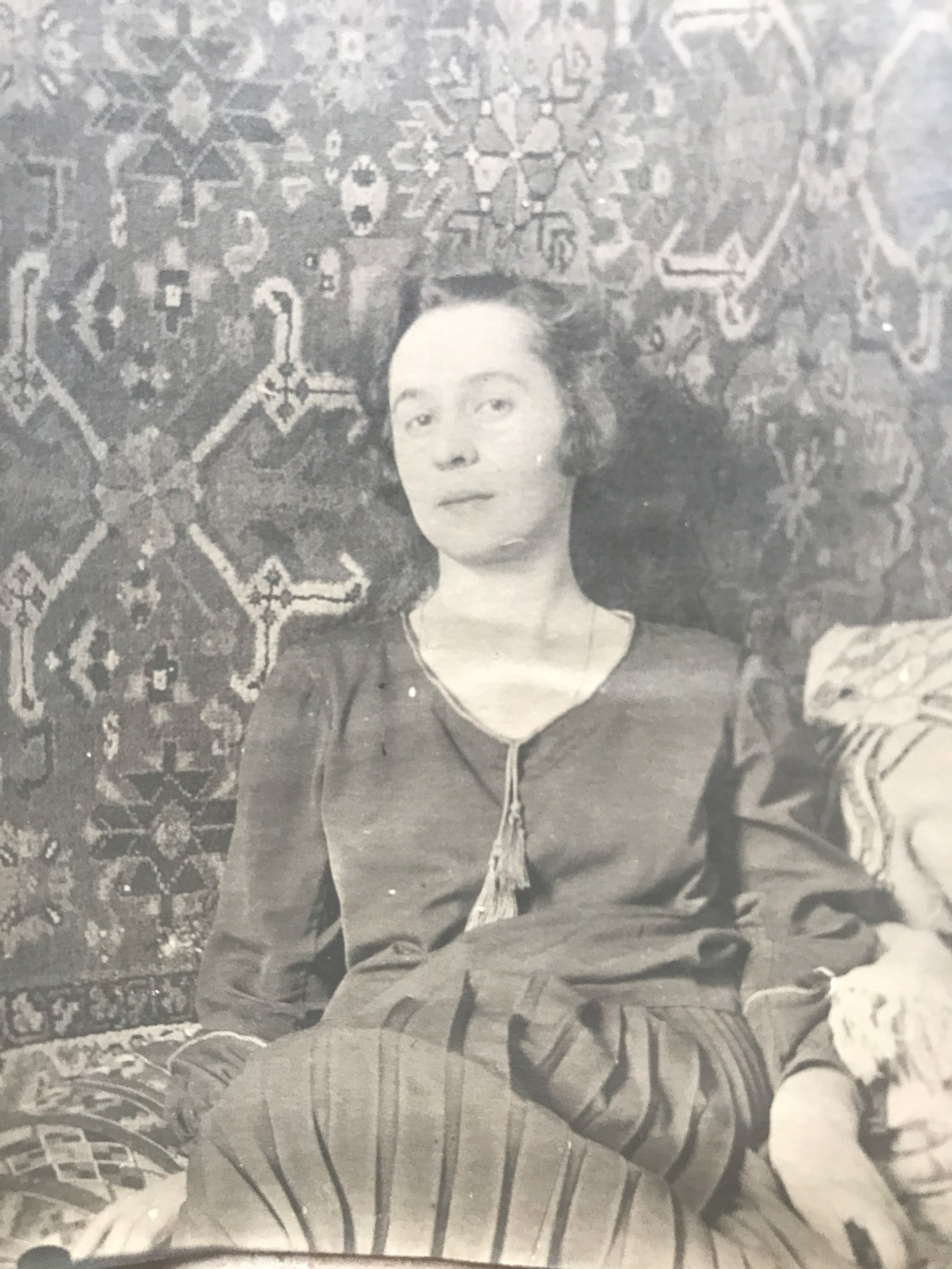 a woman in a dress leaning against a wall