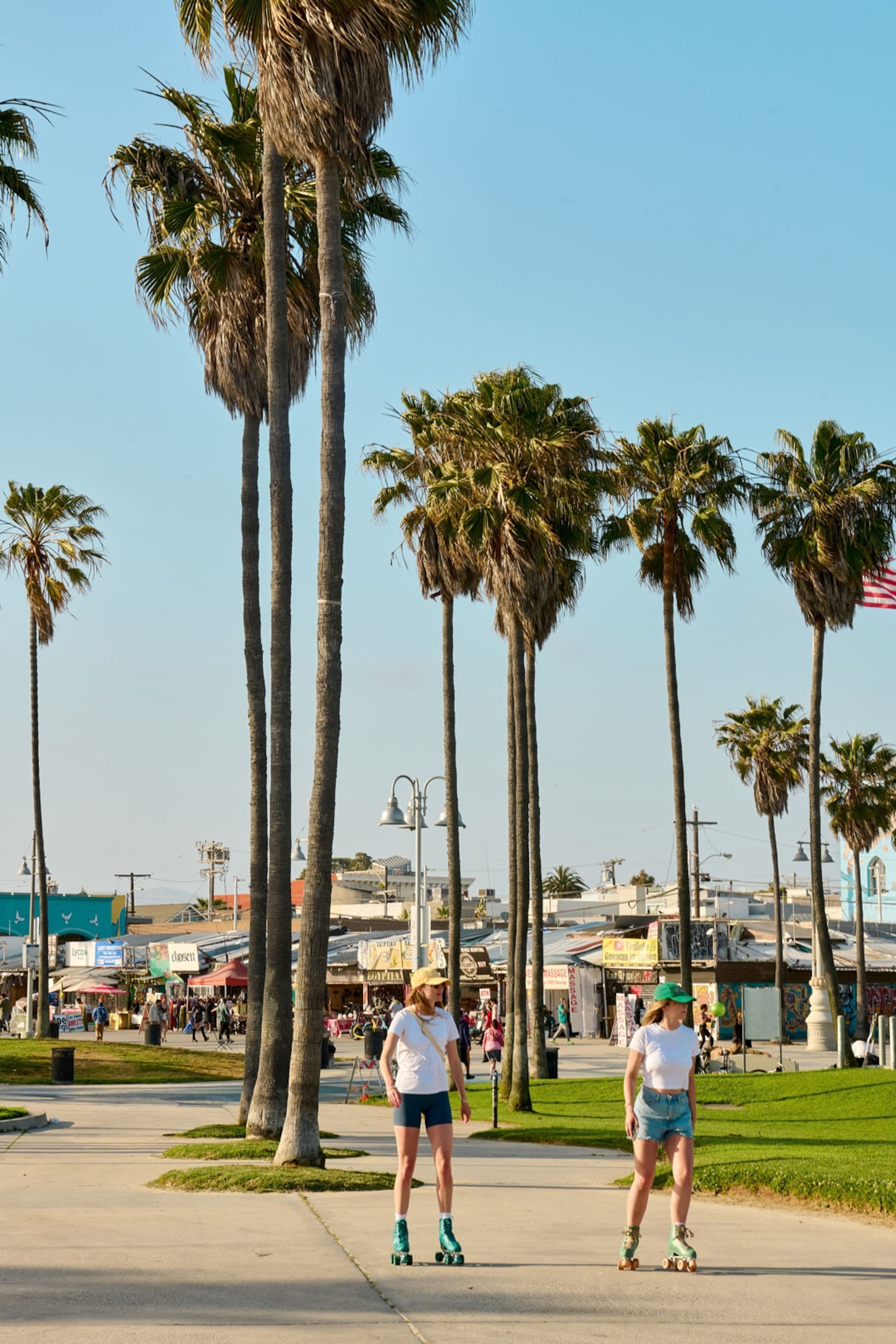 Two people rollerskating on Venice Beach.