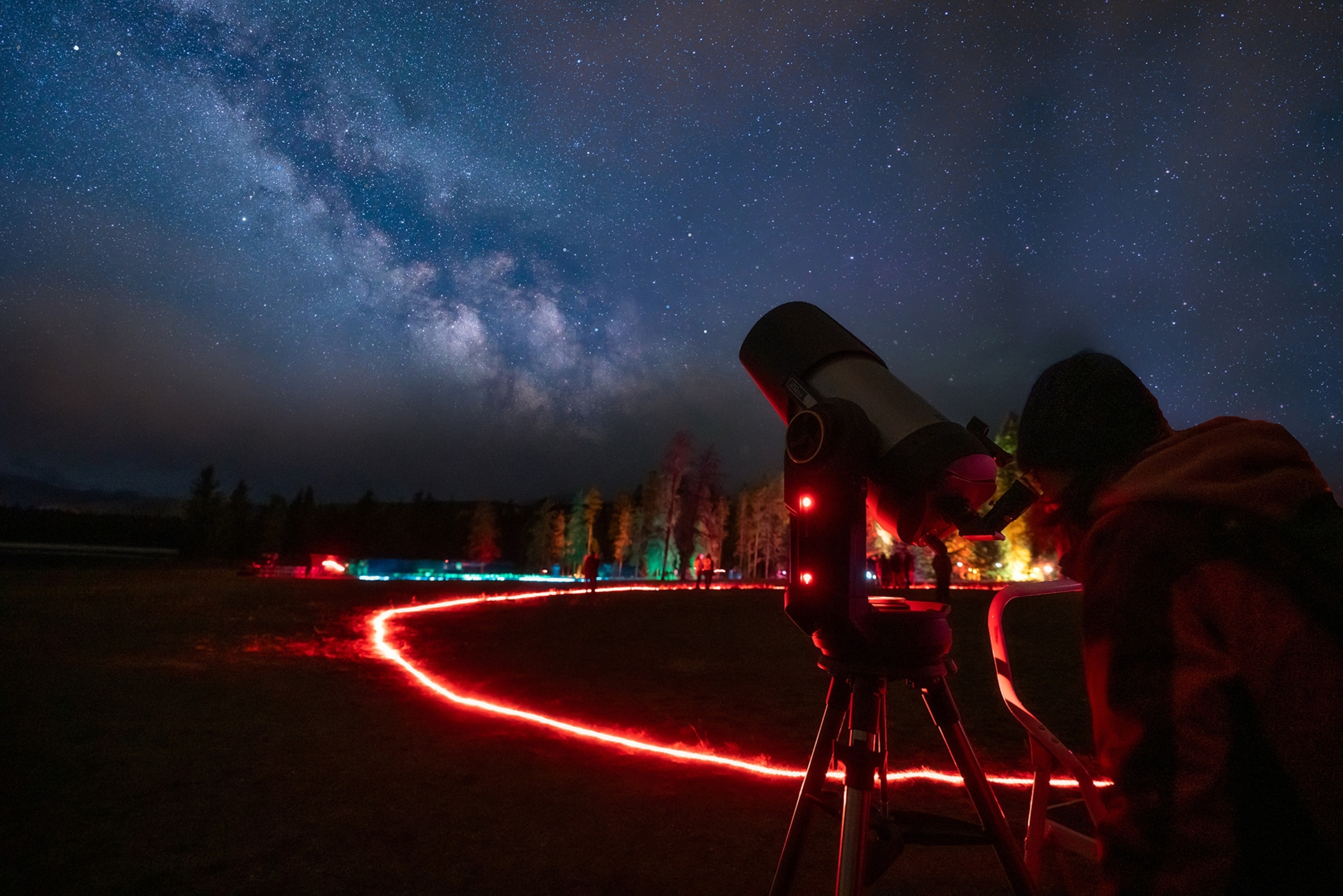 A person looks through the Planetarium Telescope at a sky filled with stars.